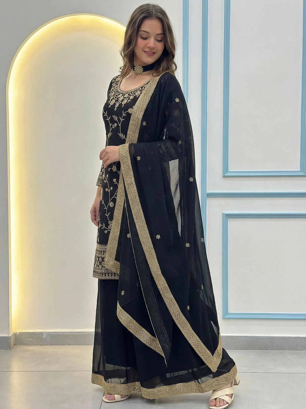 Black embroidered salwar kameez with gold detailing, perfect for ethnic wear and festive occasions.