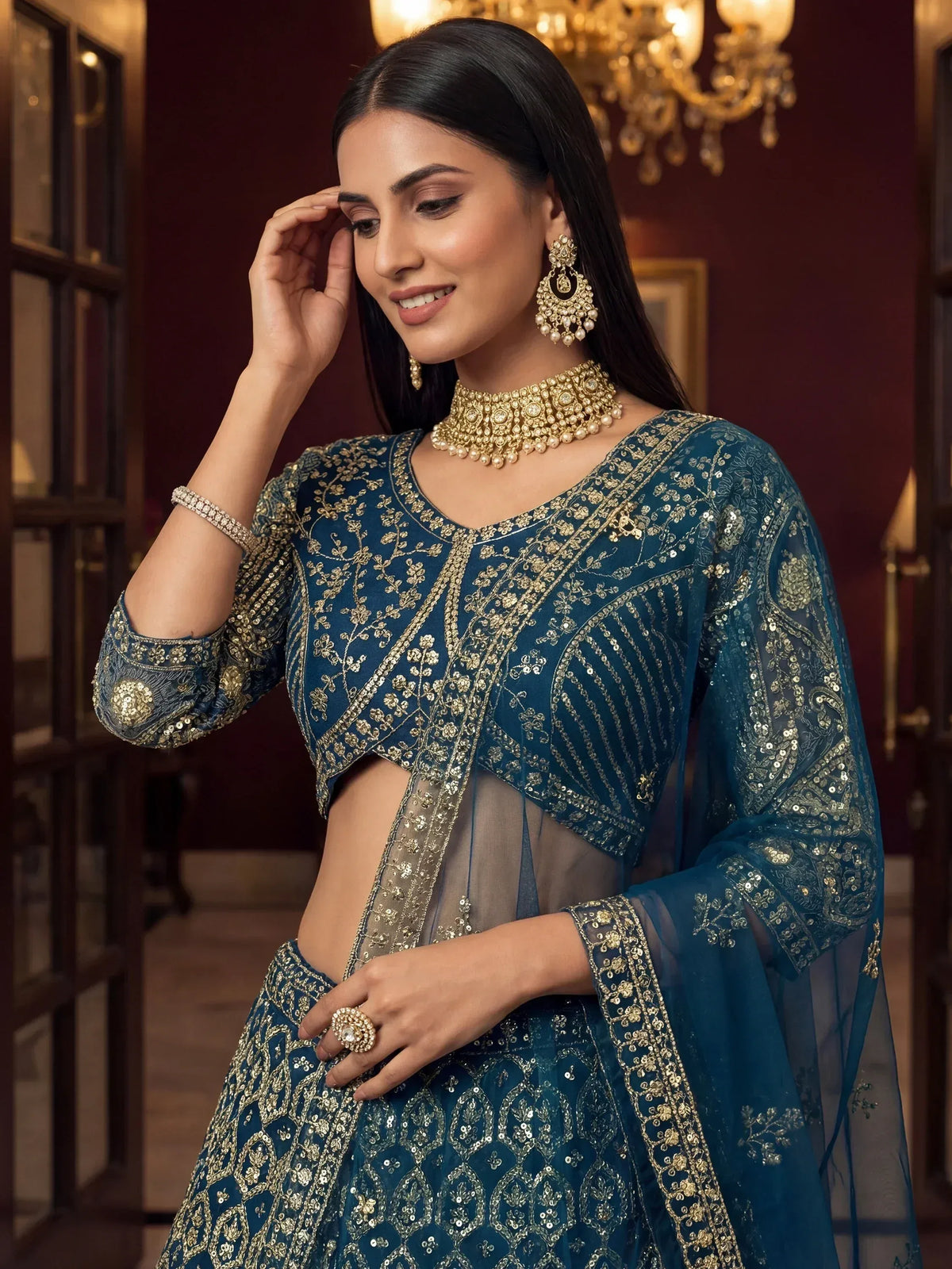 Teal blue embroidered lehenga choli with gold work, perfect for Indian weddings and festive occasions.
