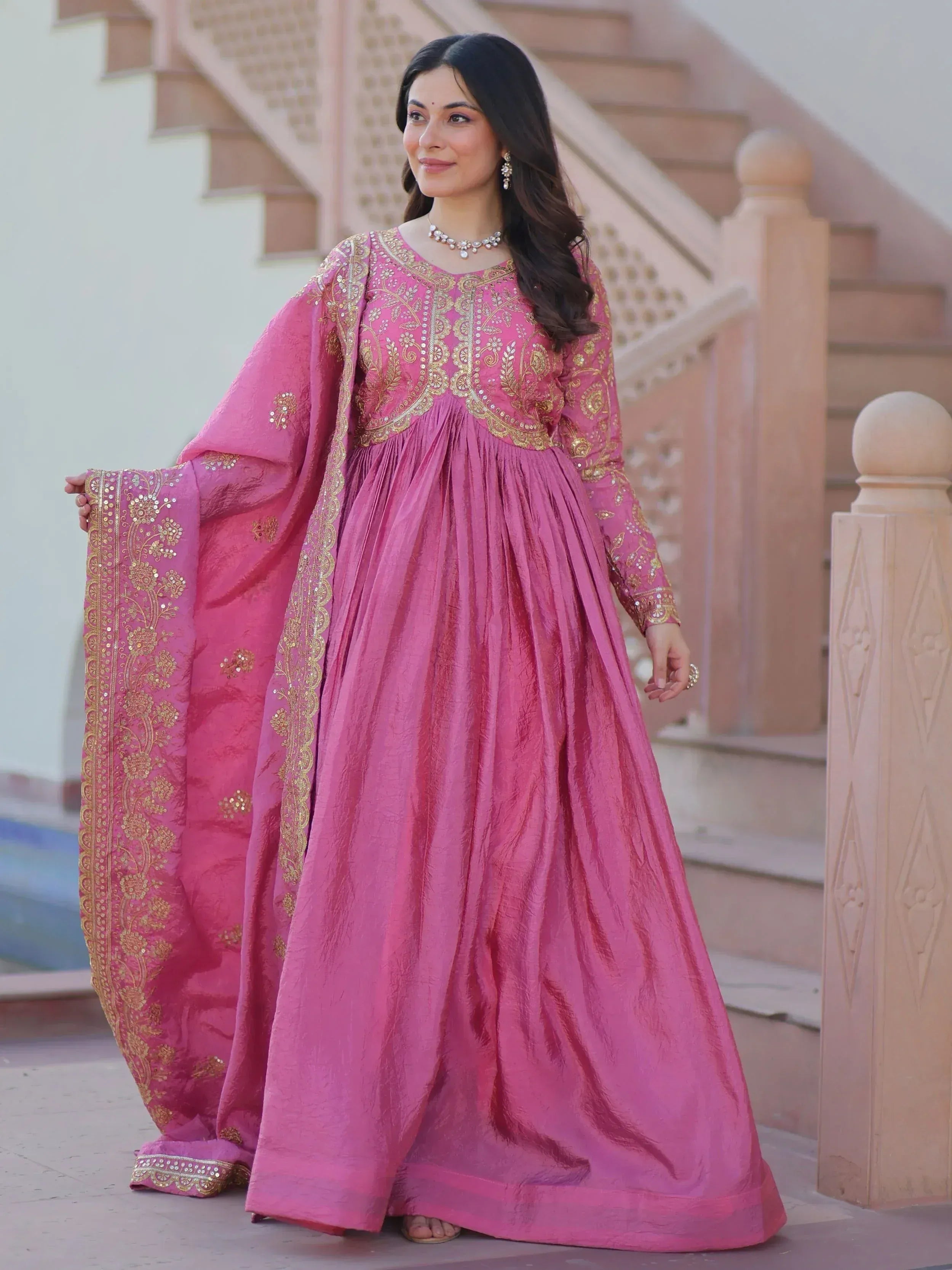 Pink ethnic gown with gold embroidery, perfect for Indian celebrations and festive occasions.