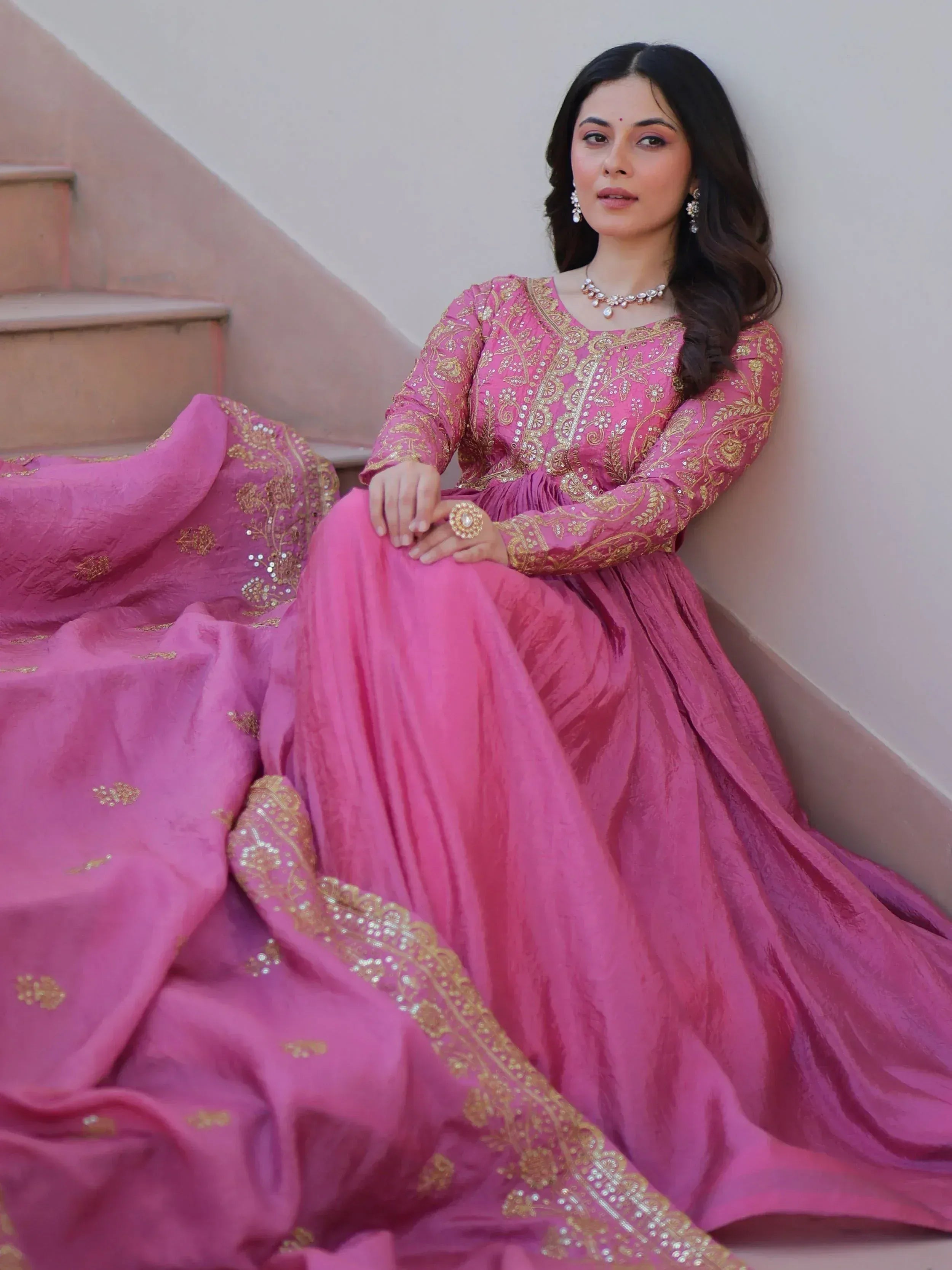 Pink embroidered Indian ethnic gown with gold detailing, perfect for weddings and festive occasions.