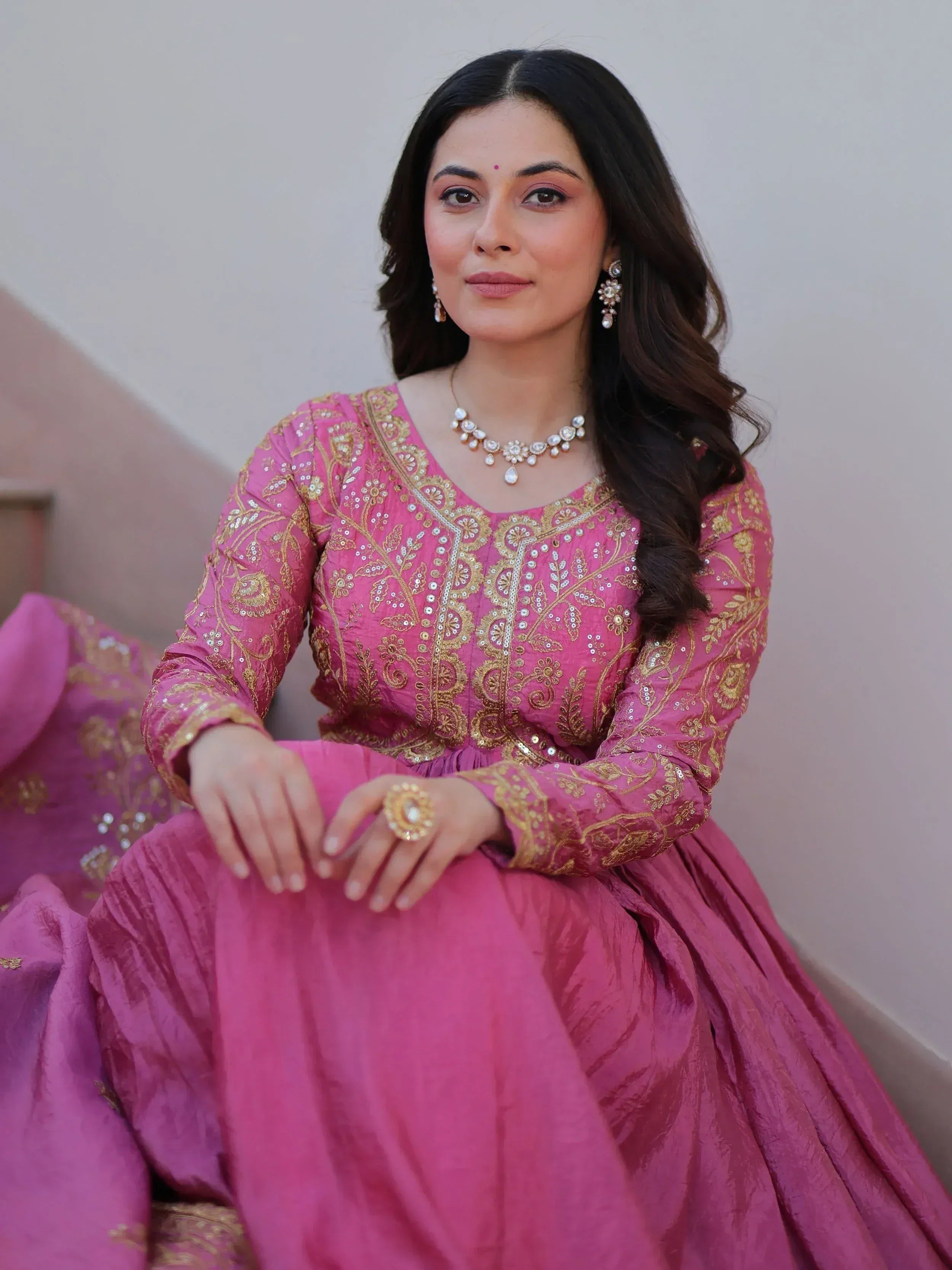 Pink embroidered ethnic gown with gold detailing, perfect for Indian weddings and festive occasions.