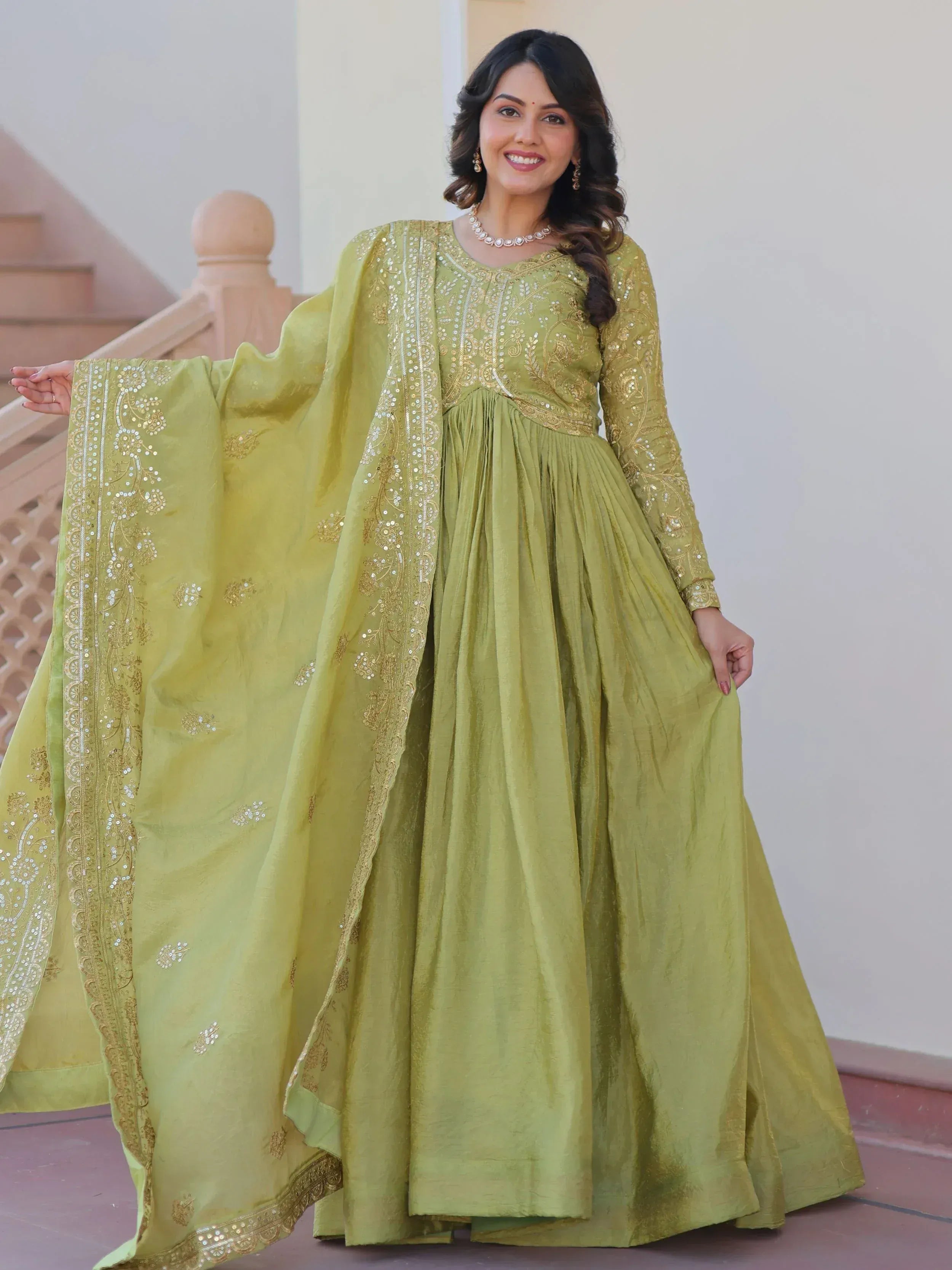 Elegant green ethnic gown with gold embroidery and sequins, perfect for Indian occasions