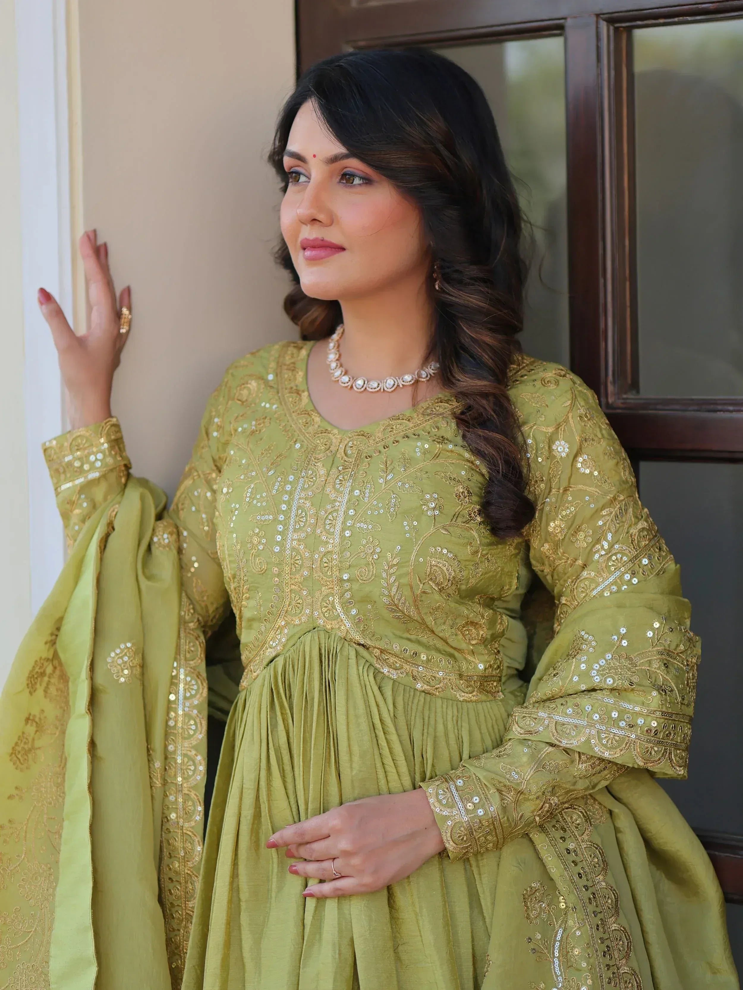 Olive green embroidered ethnic gown with gold detailing, perfect for Indian occasions and festive wear.