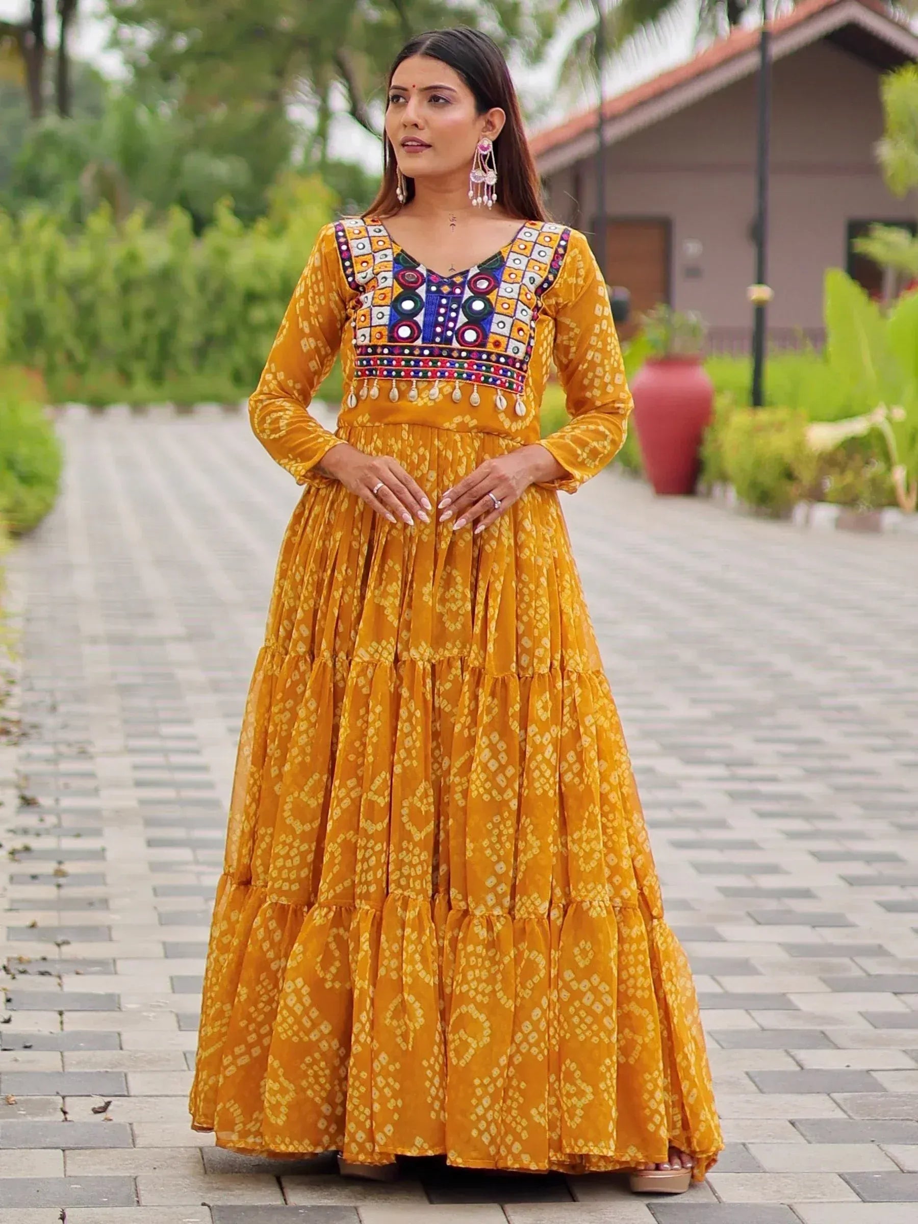 Mustard yellow ethnic gown with mirror work and tiered skirt, perfect for Indian occasions