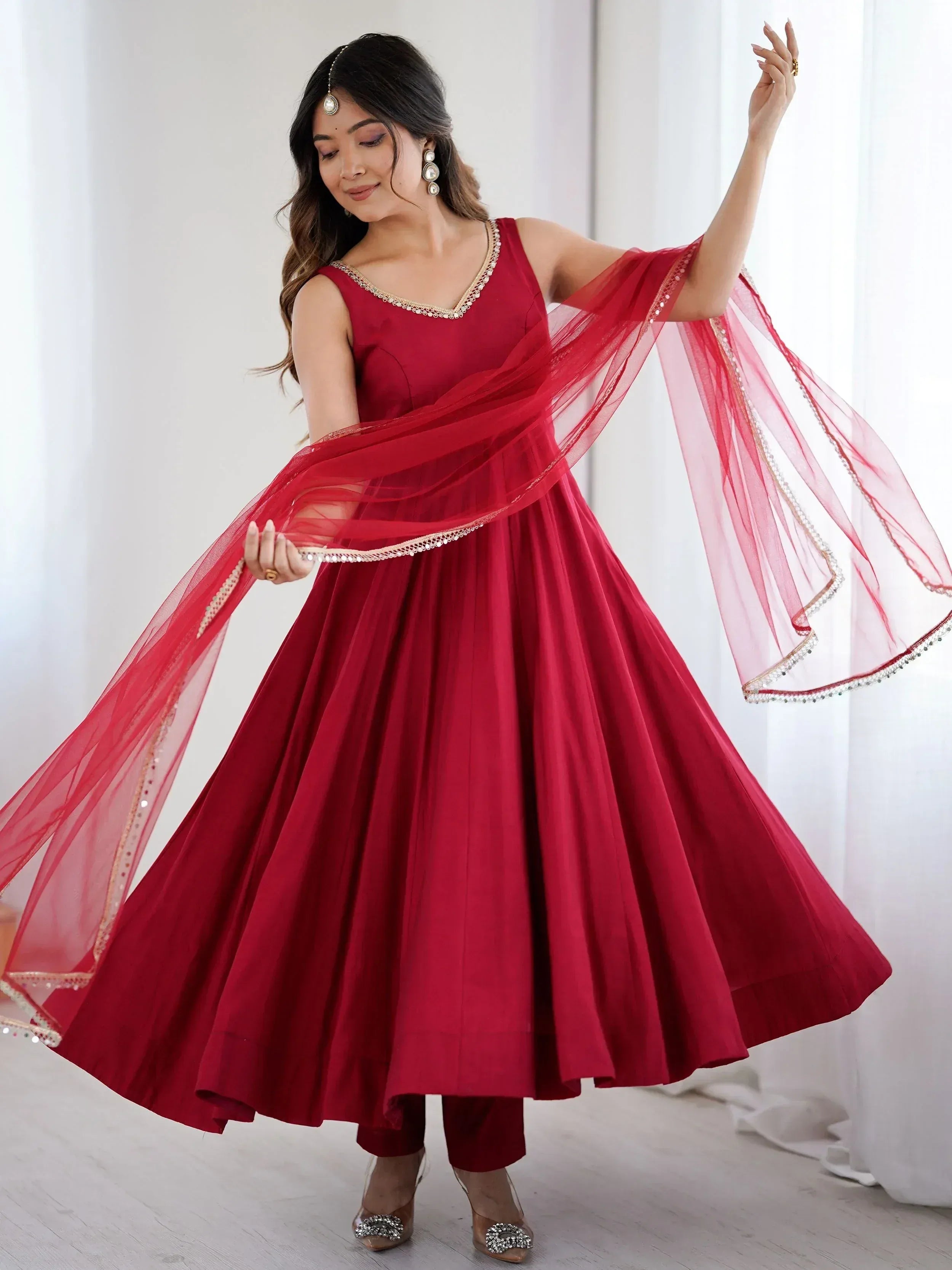 Red ethnic anarkali gown with sheer dupatta, perfect for Indian weddings and festive occasions.