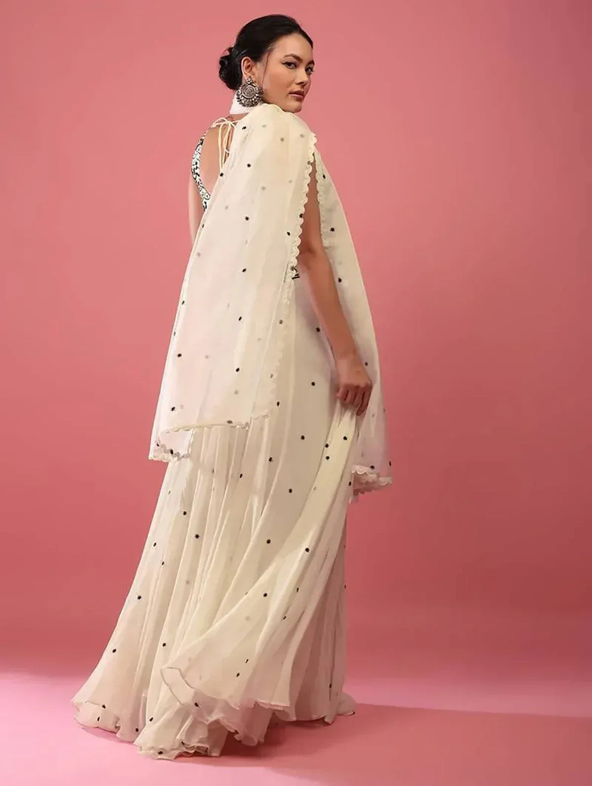 Elegant white ethnic gown with black dot detailing and sheer cape, perfect for Indian occasions.