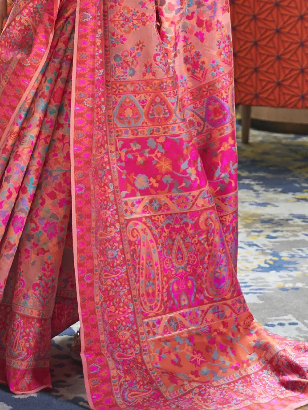 Vibrant pink and orange floral paisley saree with intricate border design, perfect for ethnic occasions.