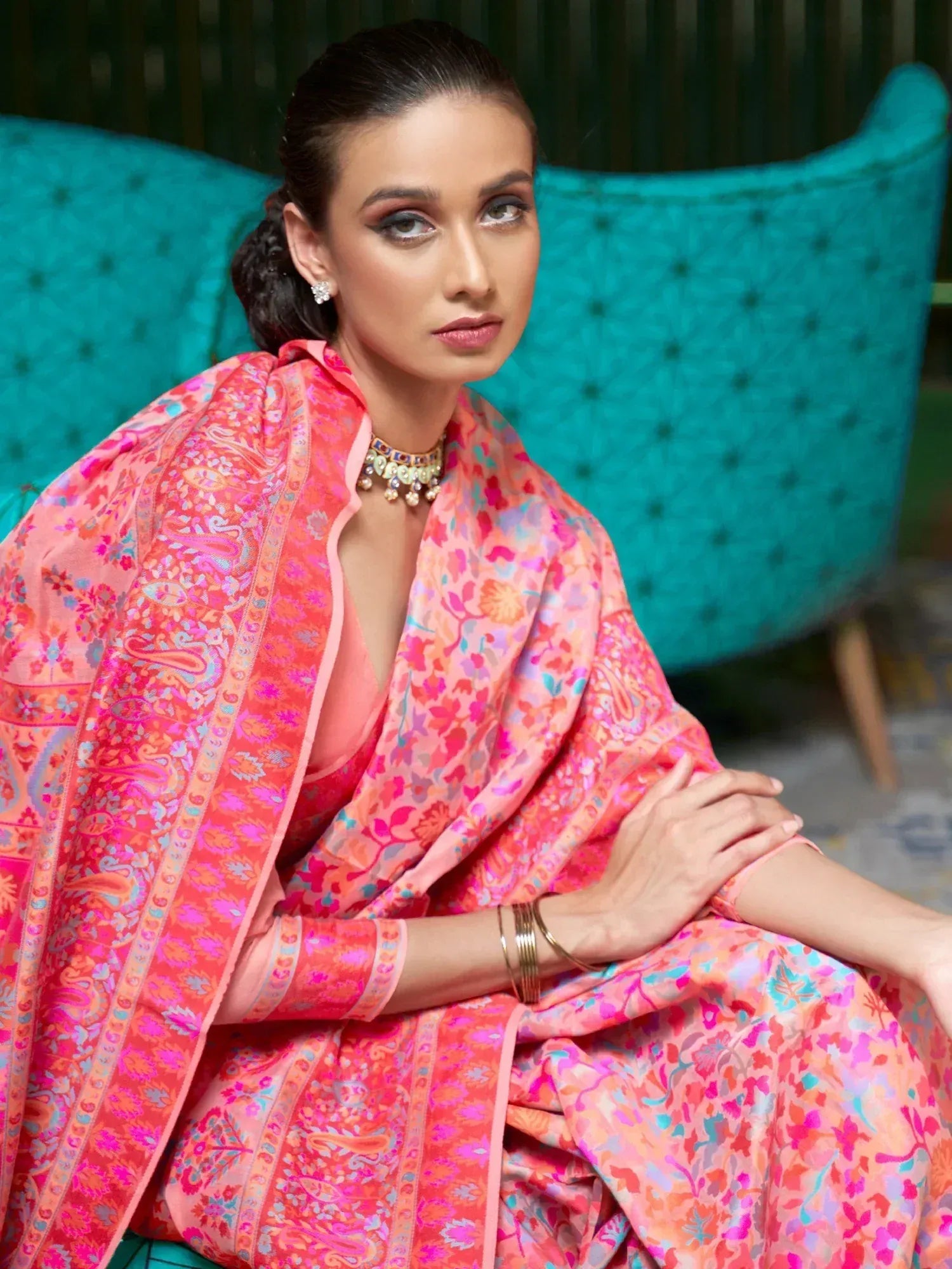 Woman in vibrant pink floral ethnic gown with paisley dupatta, styled for festive occasions