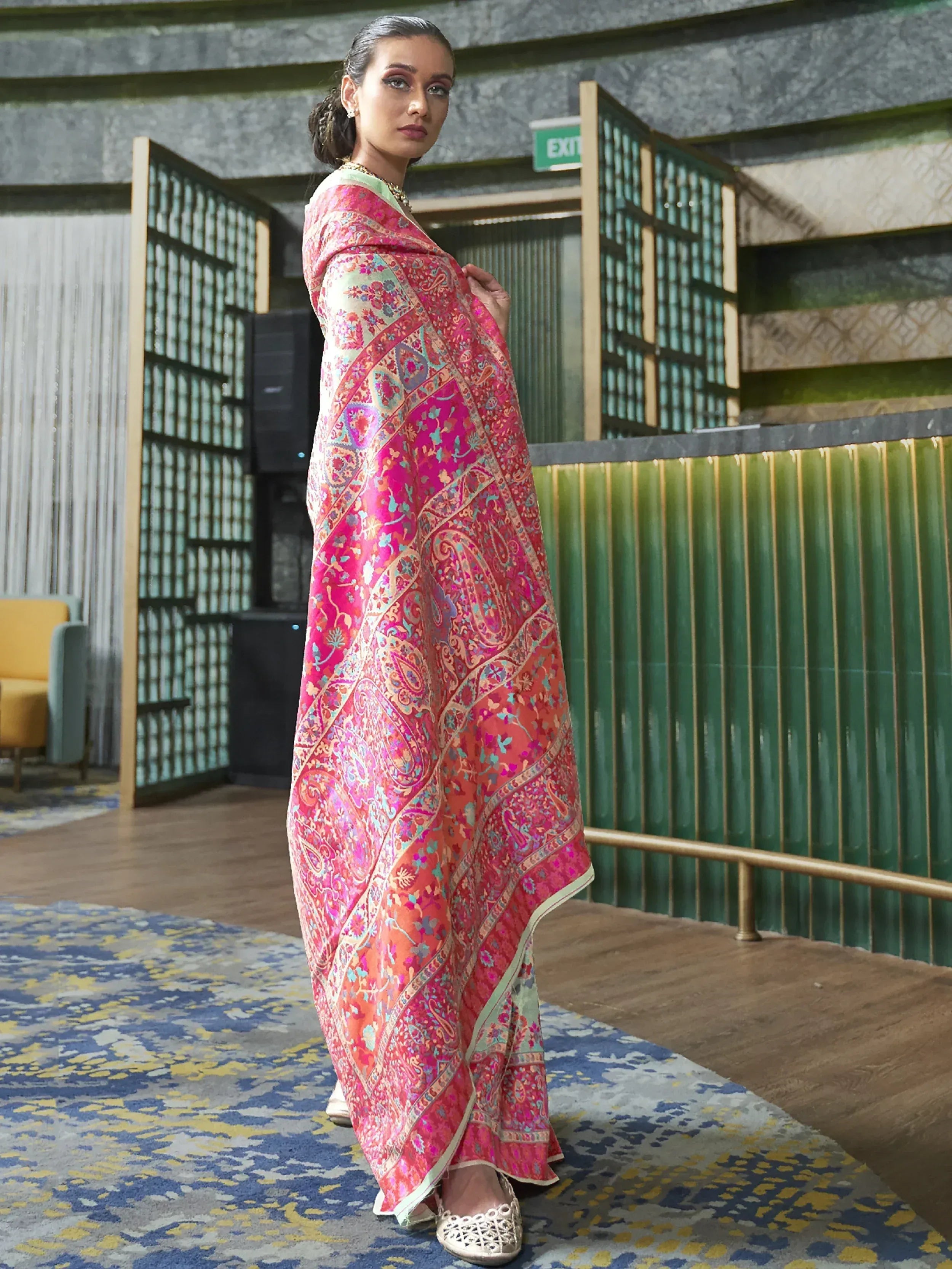 Woman in vibrant pink paisley printed ethnic gown, perfect for Indian festive occasions and parties.