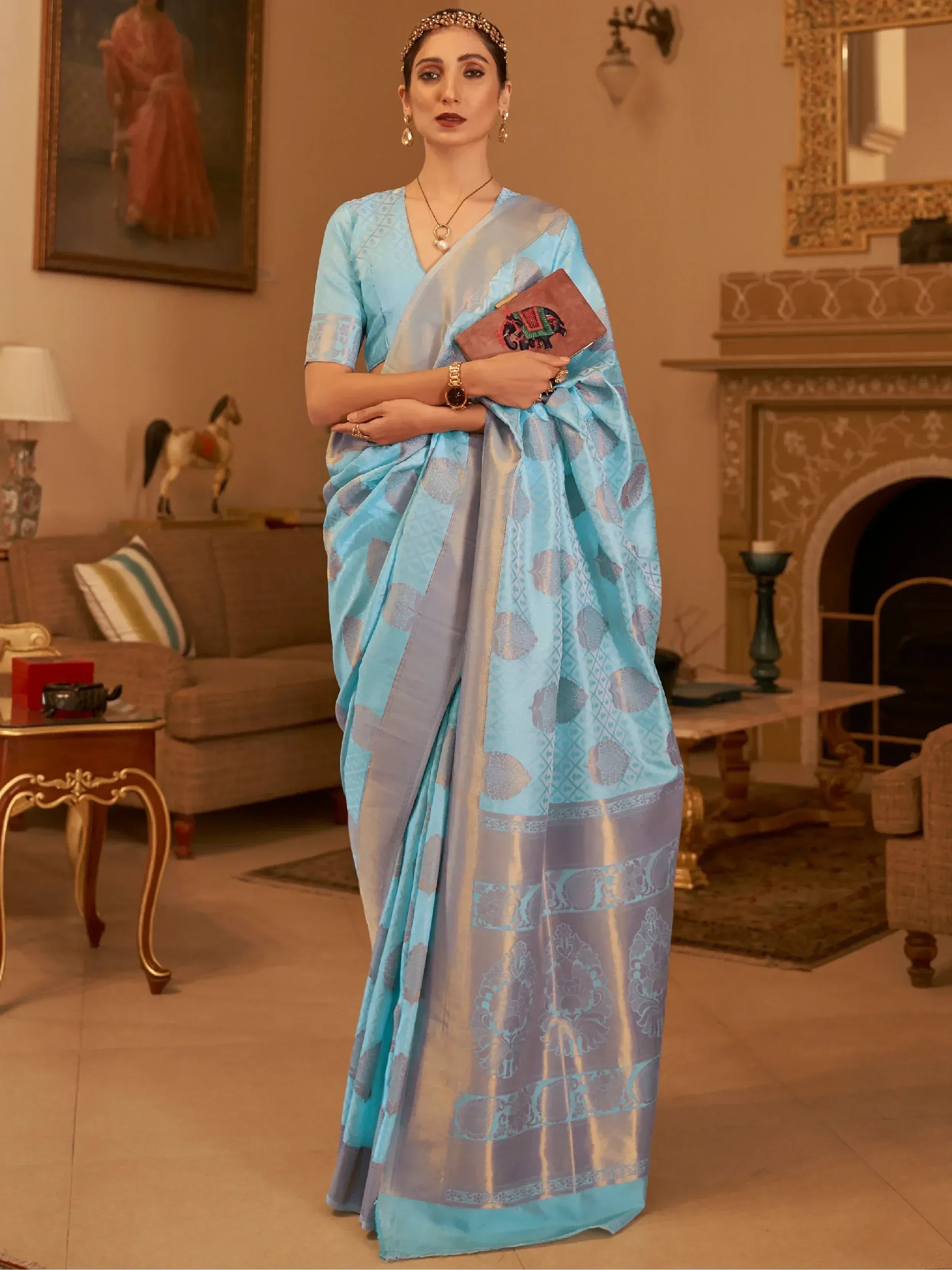 Woman in elegant light blue designer saree with intricate patterns, perfect for Indian ethnic wear occasions