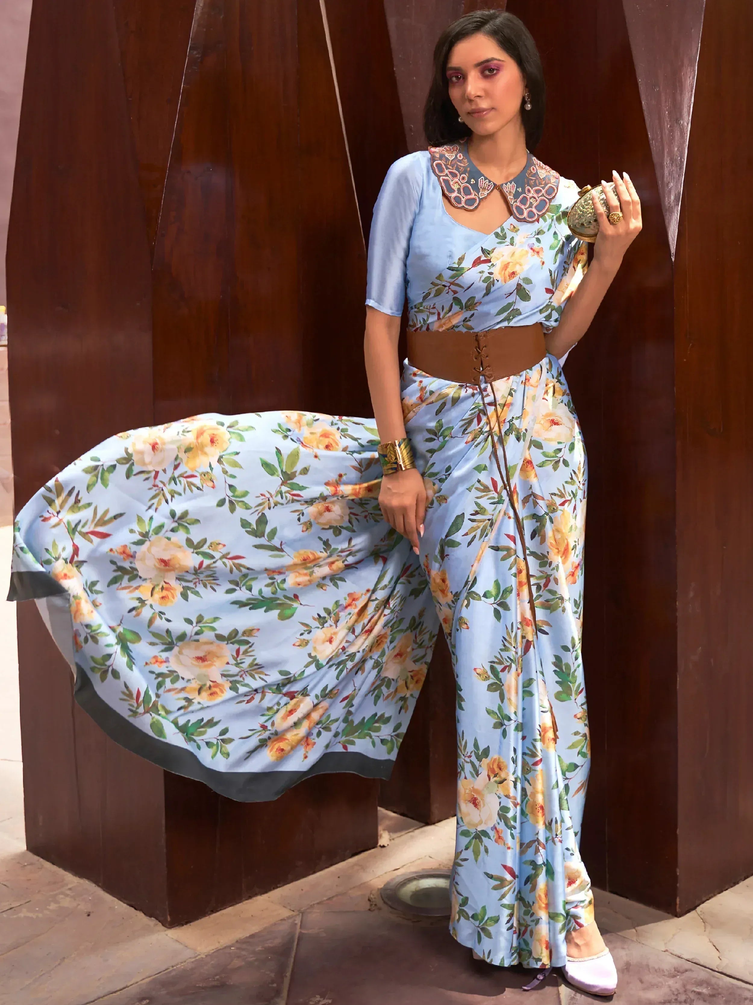 Light blue floral printed ethnic gown with embroidered collar and brown belt, styled for modern Indian wear