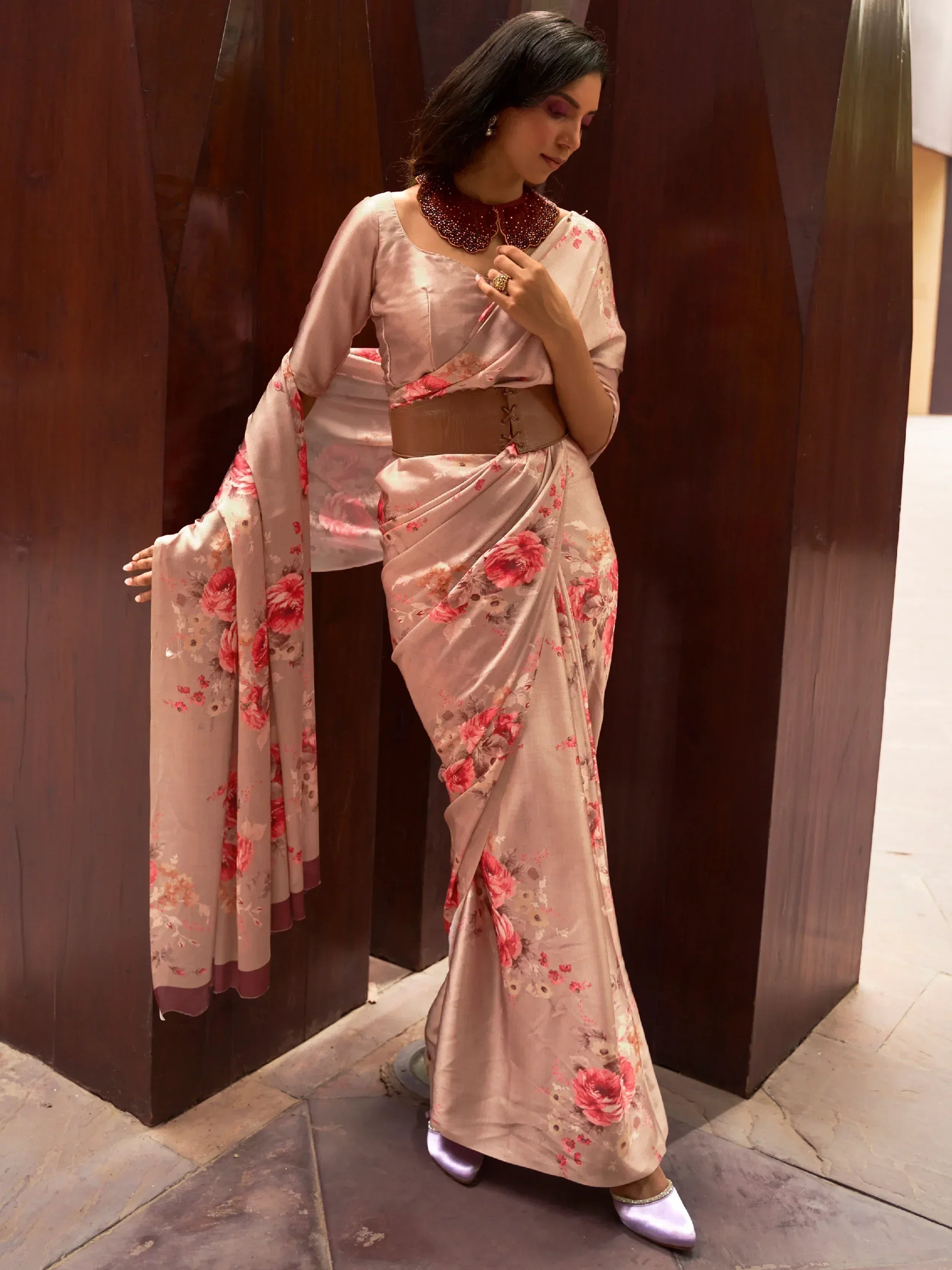 Floral print saree with embellished neckline, brown belt, and purple heels for ethnic wear