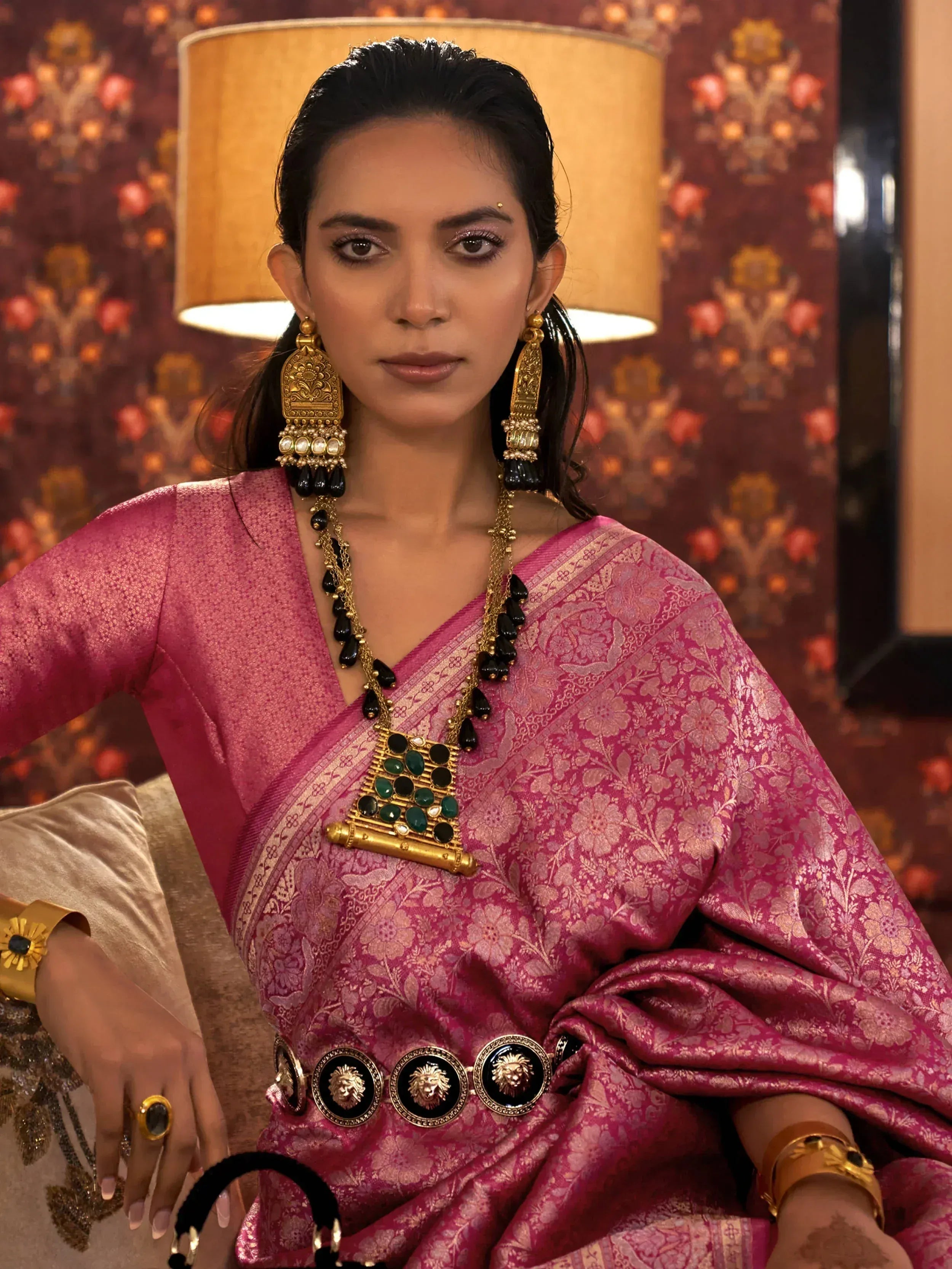 Woman in pink floral saree with gold jewelry, ethnic Indian wear