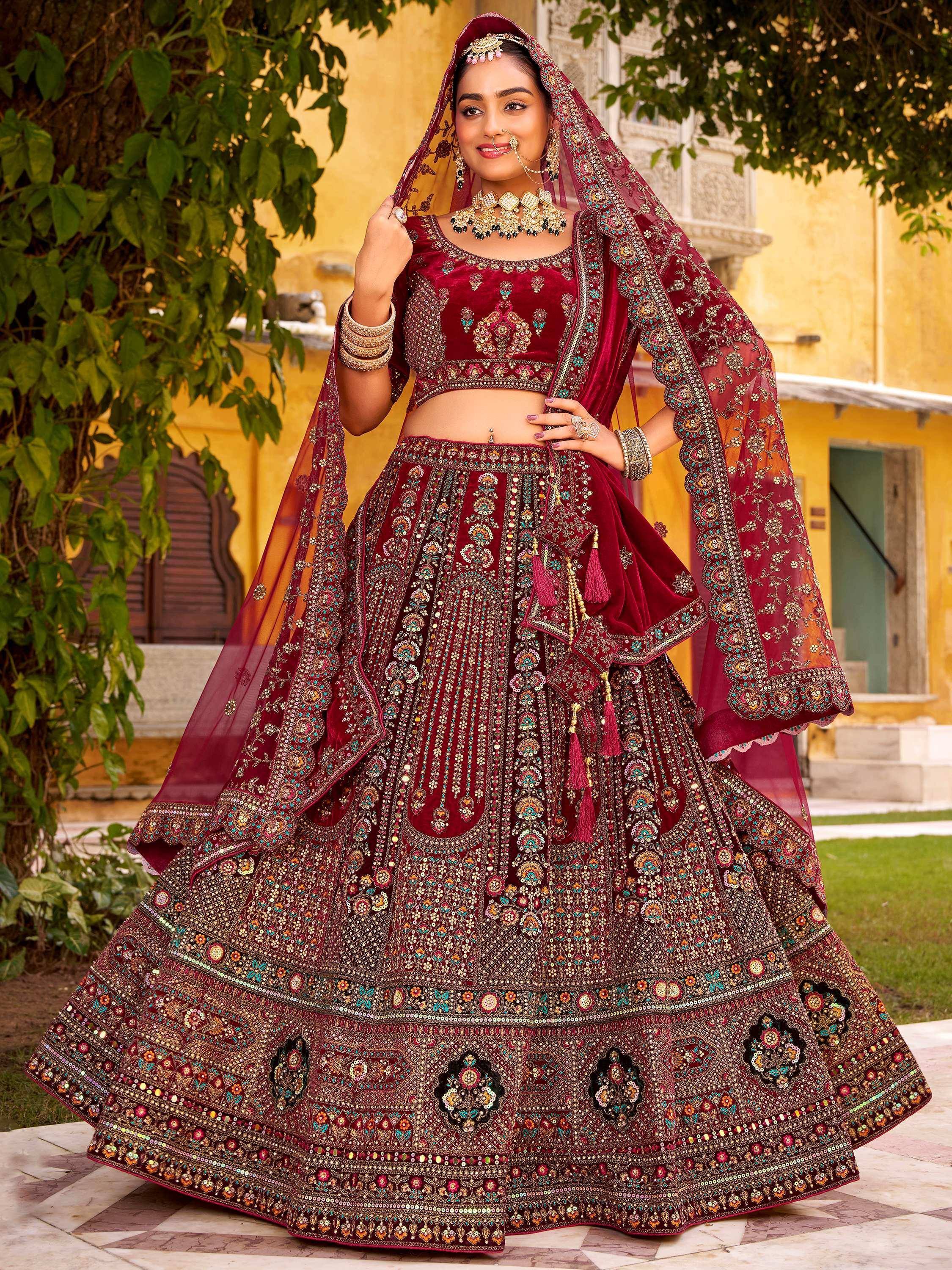Maroon velvet designer lehenga choli with heavy embroidery, perfect for Indian weddings and festive occasions.