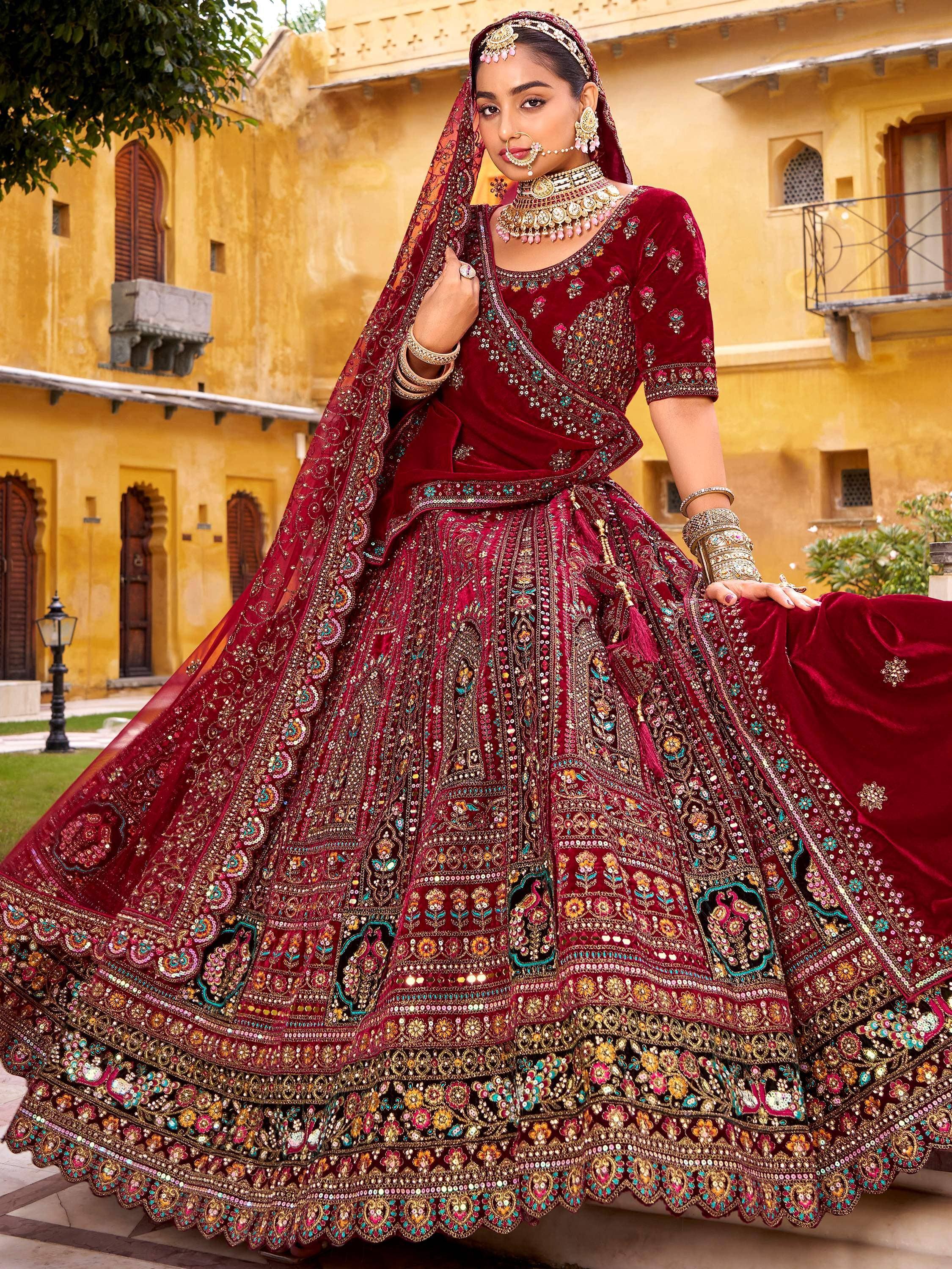 Maroon velvet designer lehenga choli with heavy embroidery, perfect for Indian weddings and festive occasions.