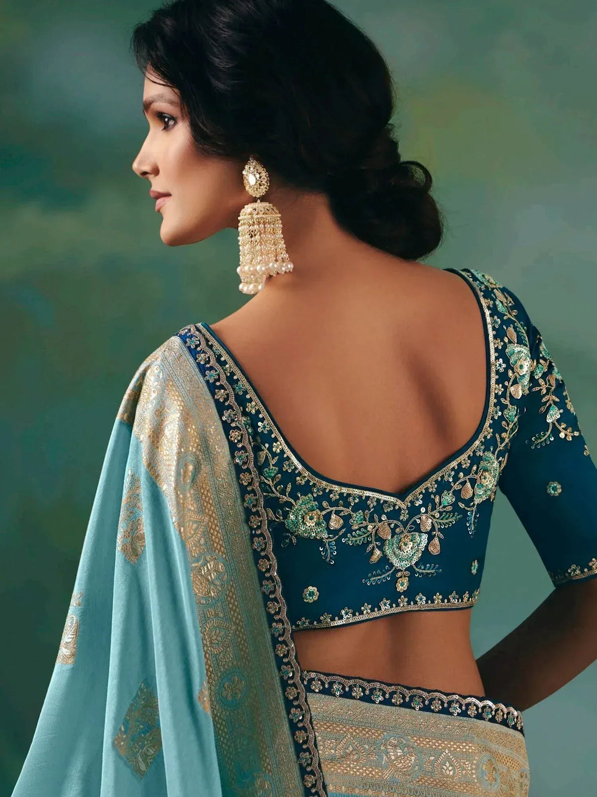 Elegant teal designer lehenga choli with gold embroidery and pearl jhumka earrings