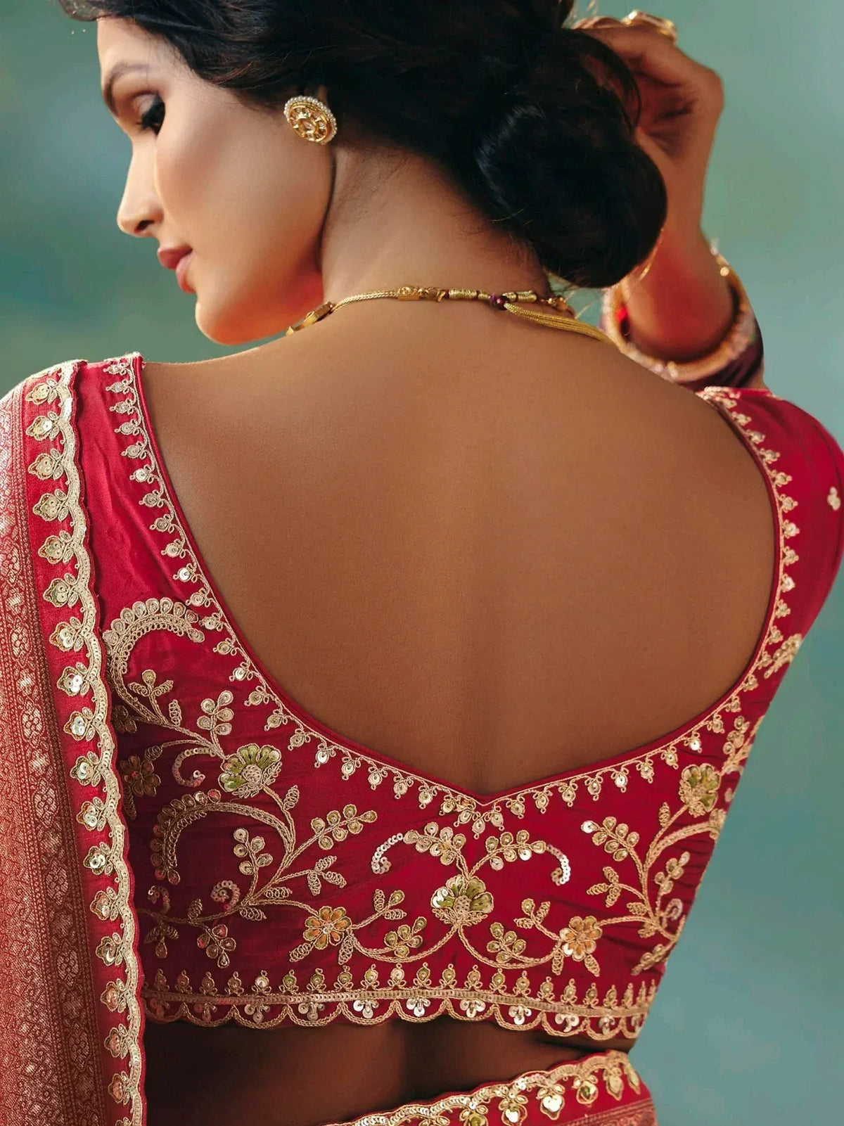 Red embroidered lehenga choli with gold floral detailing and open back design