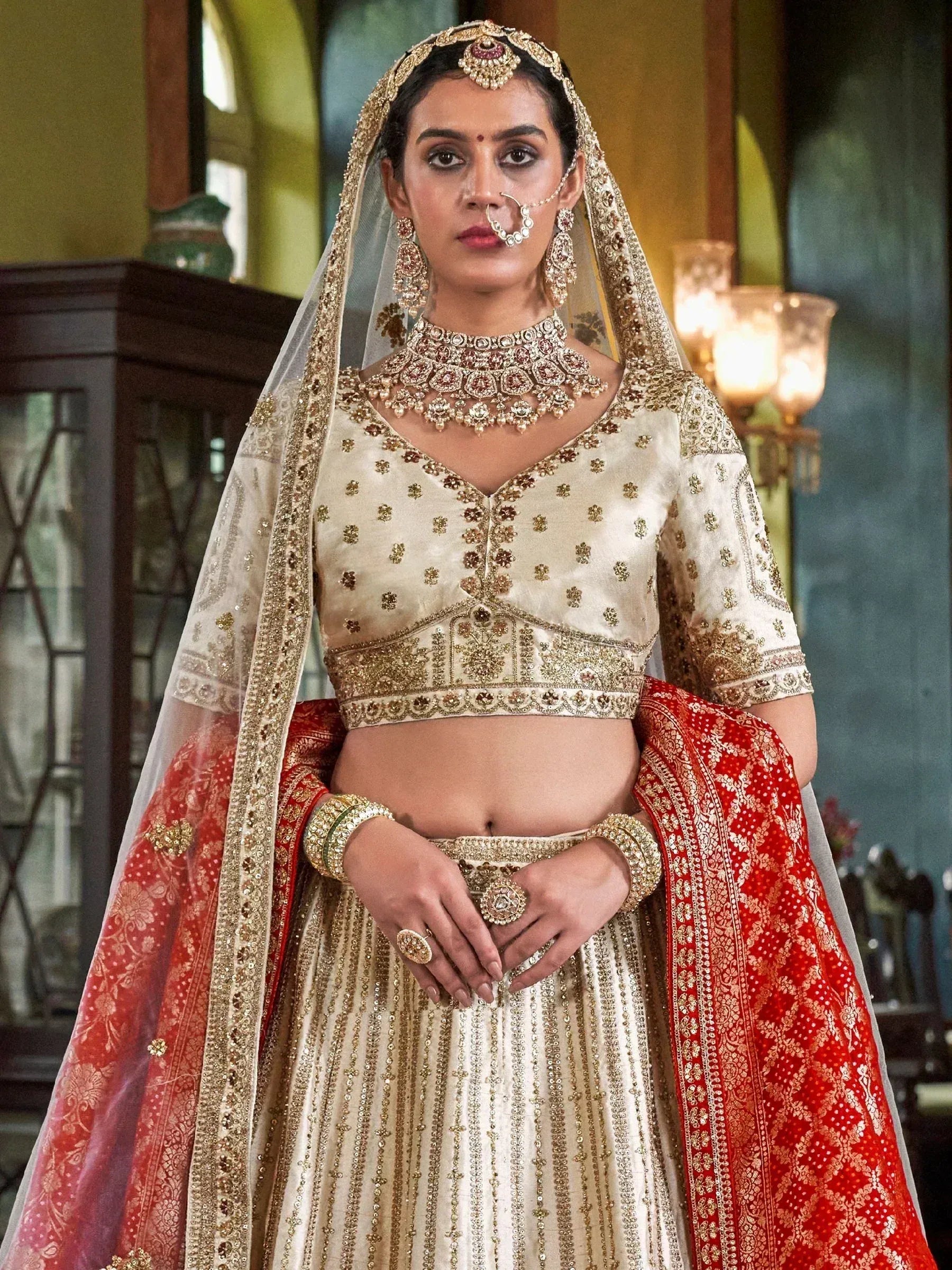 Elegant ivory and red bridal lehenga choli with gold embroidery, traditional Indian wedding attire