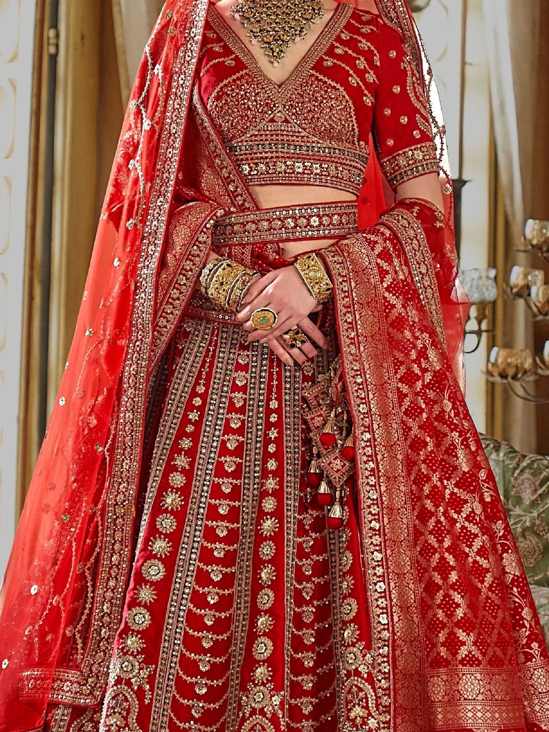 Red bridal lehenga choli with heavy gold embroidery and matching dupatta, traditional Indian wedding attire