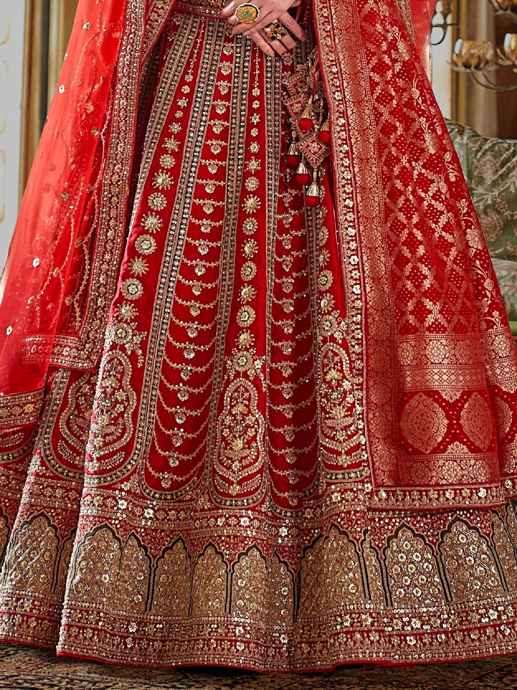 Red bridal lehenga choli with heavy gold embroidery and sequins, perfect for Indian weddings