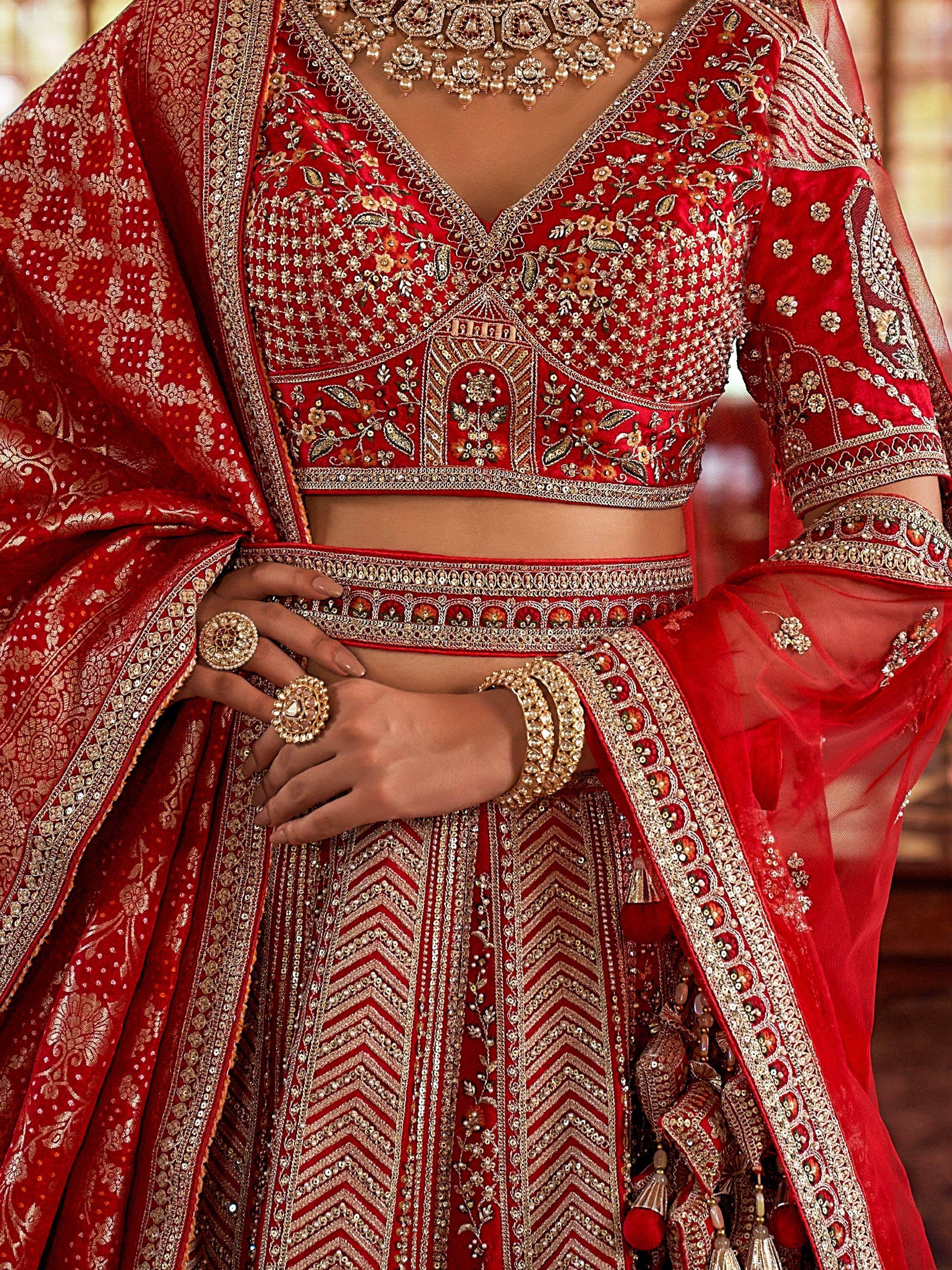 Red embroidered lehenga choli with gold detailing, perfect for Indian weddings and festive occasions.