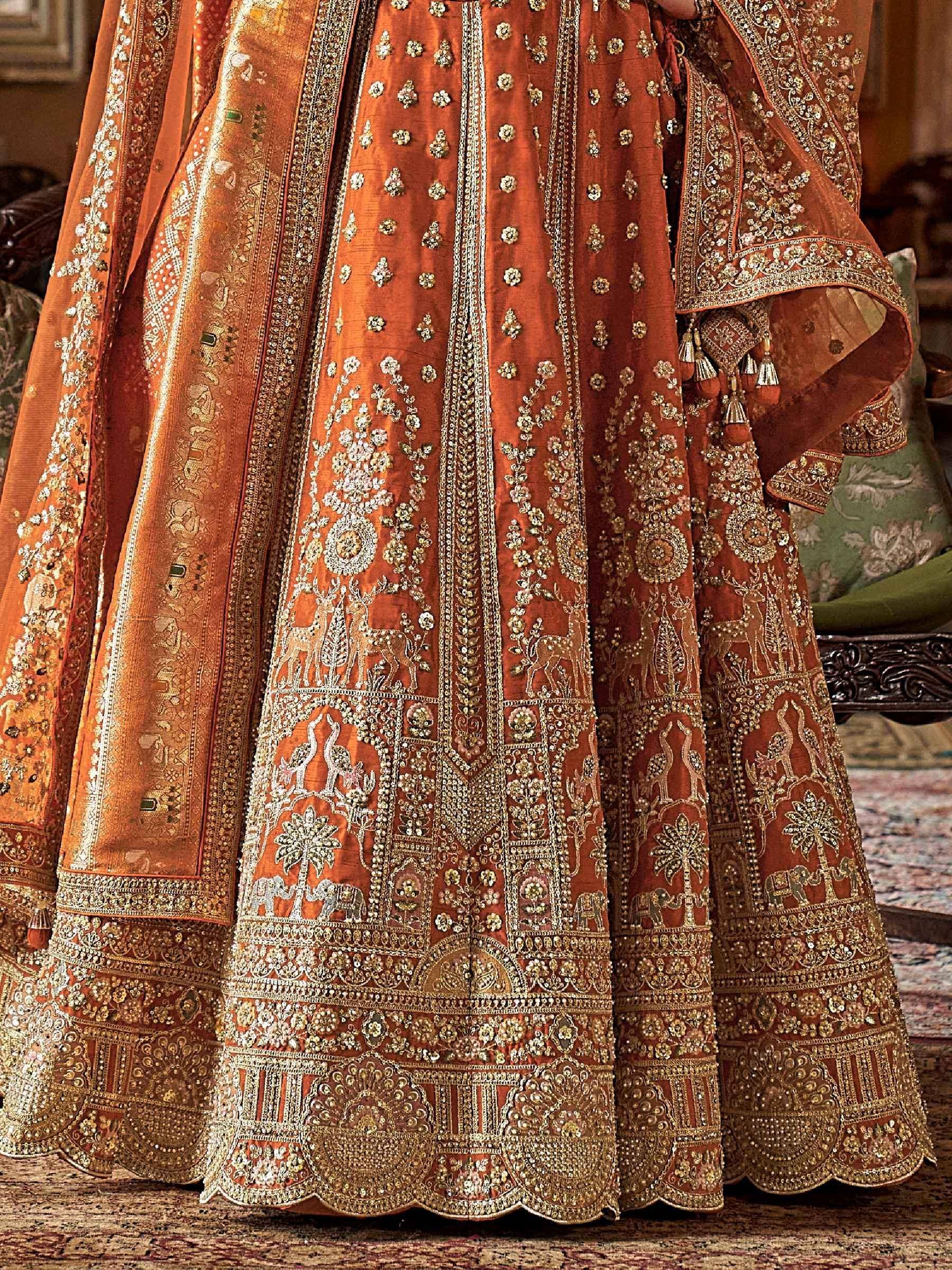 Richly embroidered orange lehenga choli with gold wildlife motifs, perfect for Indian ethnic wear