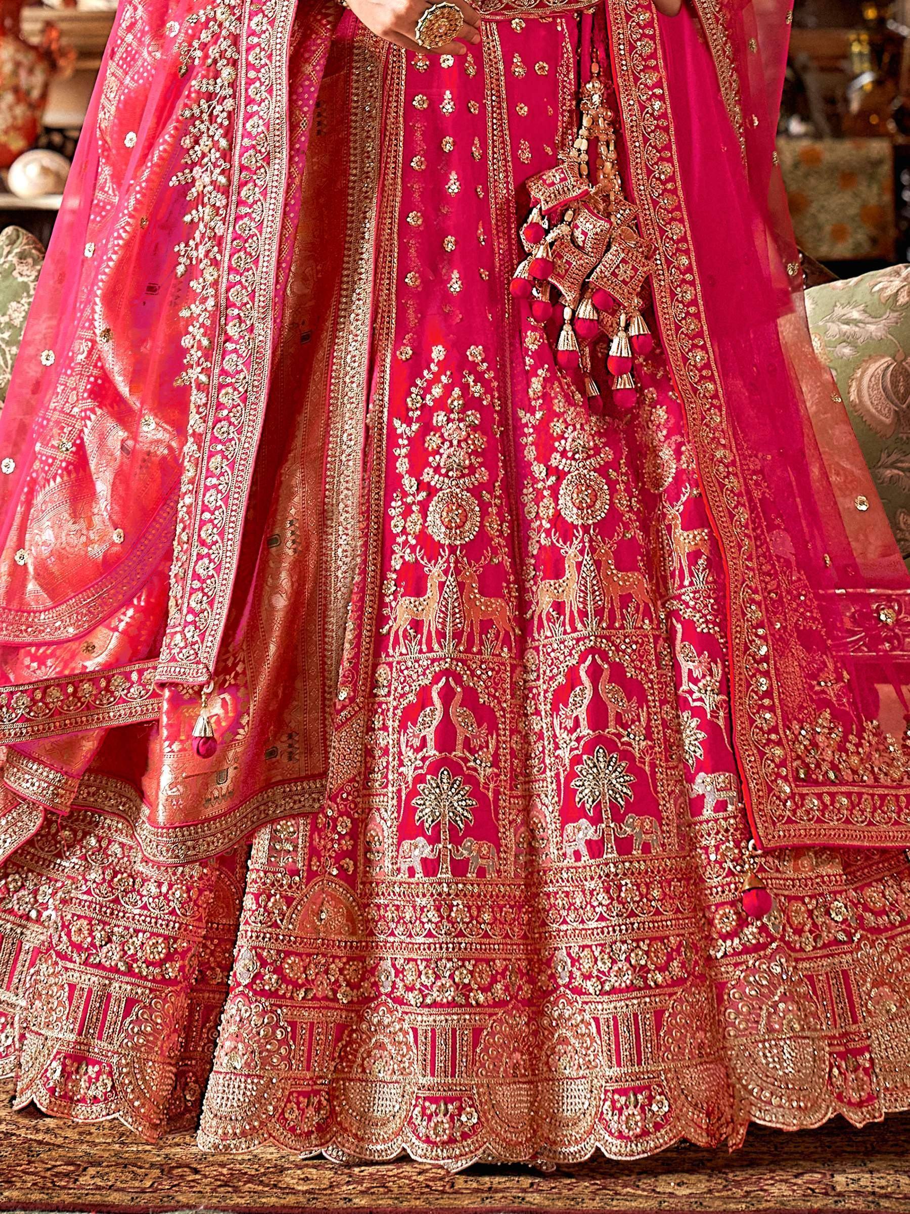 Fuchsia designer lehenga choli with gold embroidery, deer & peacock motifs, perfect for Indian weddings