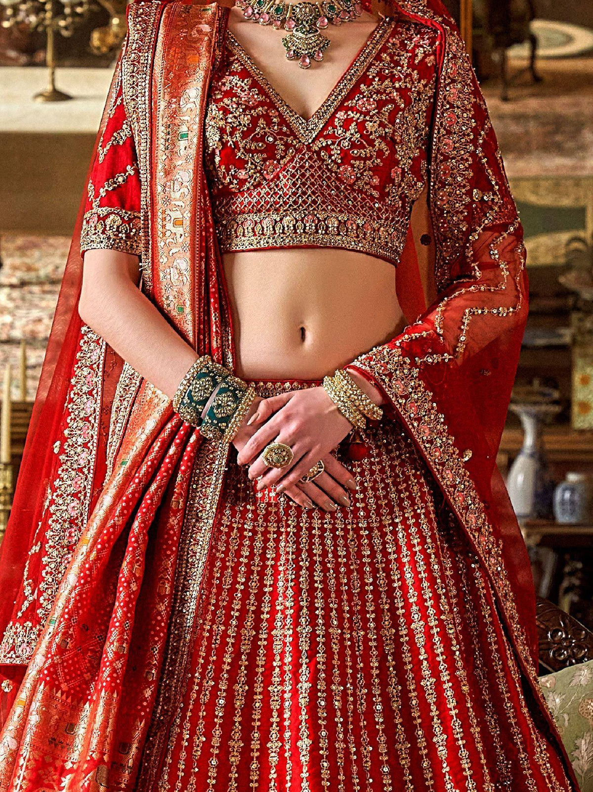 Red designer lehenga choli with heavy gold embroidery and matching dupatta, perfect for Indian weddings