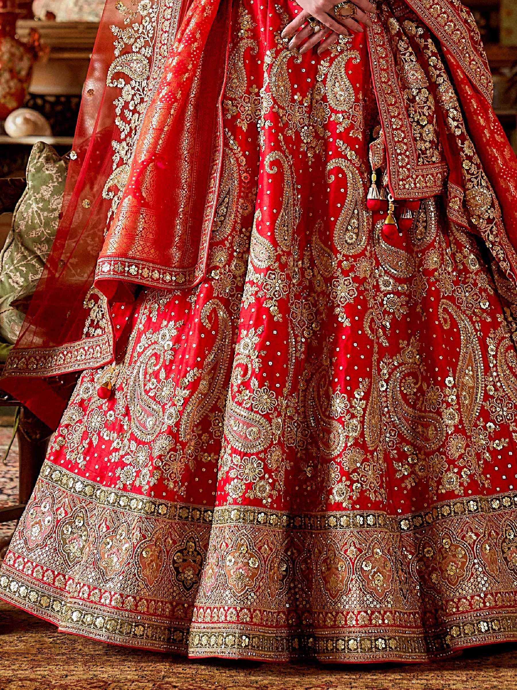 Red bridal lehenga with gold embroidery and paisley design, perfect for Indian weddings