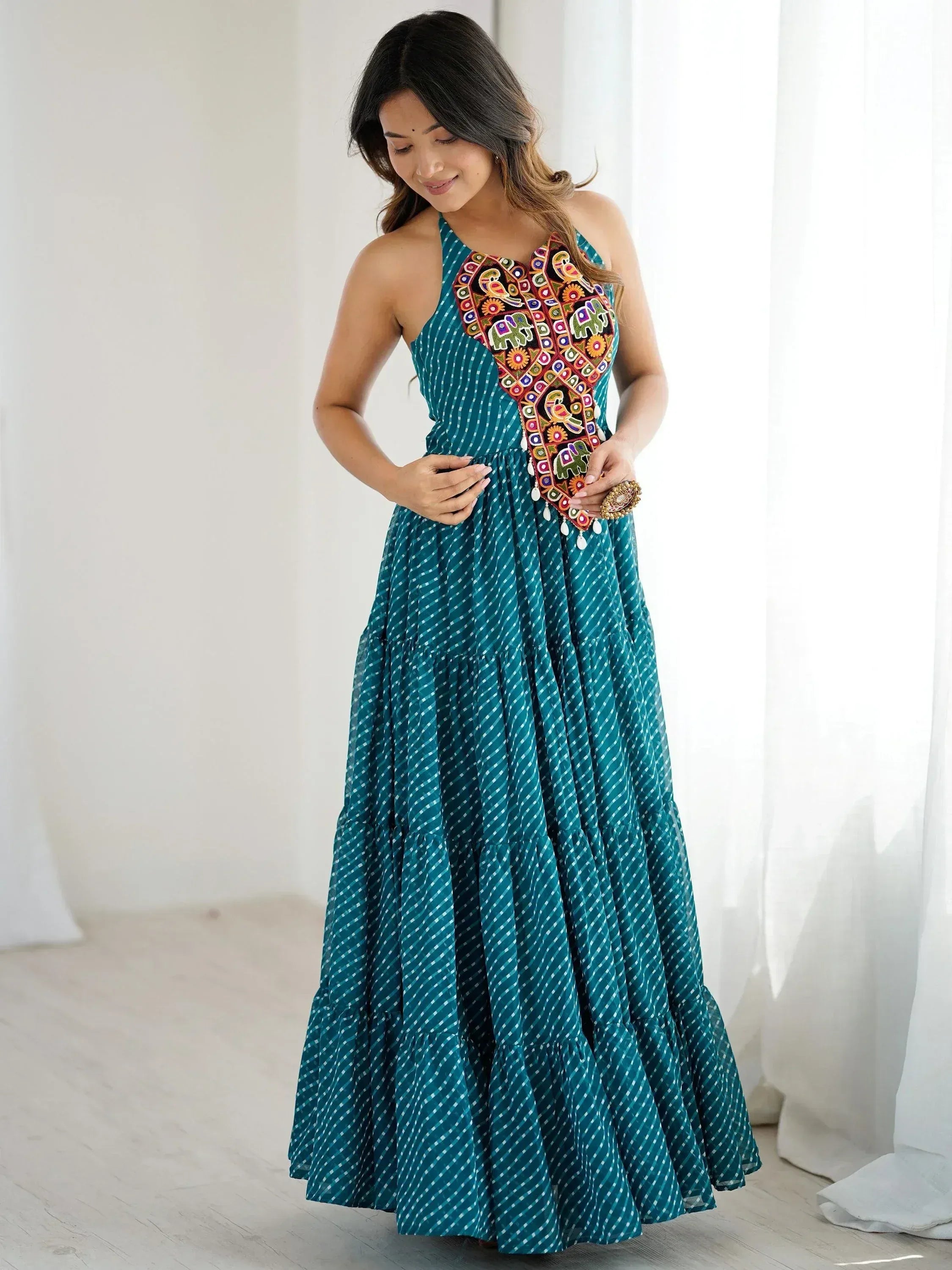 Teal ethnic gown with colorful embroidered panel, tiered skirt, and halter neck design for women