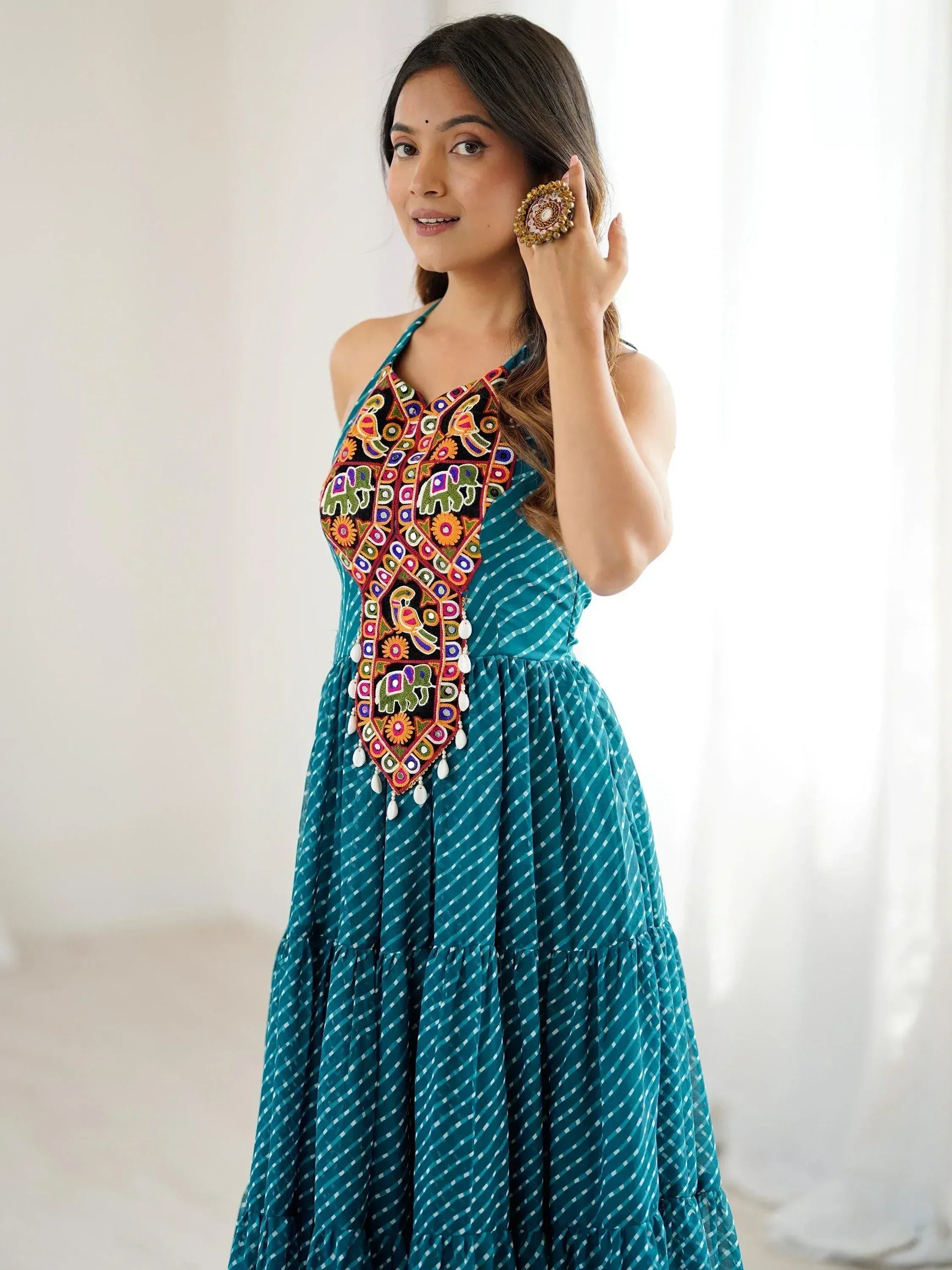 Teal ethnic gown with colorful elephant embroidery and tiered skirt, perfect for Indian festive wear.