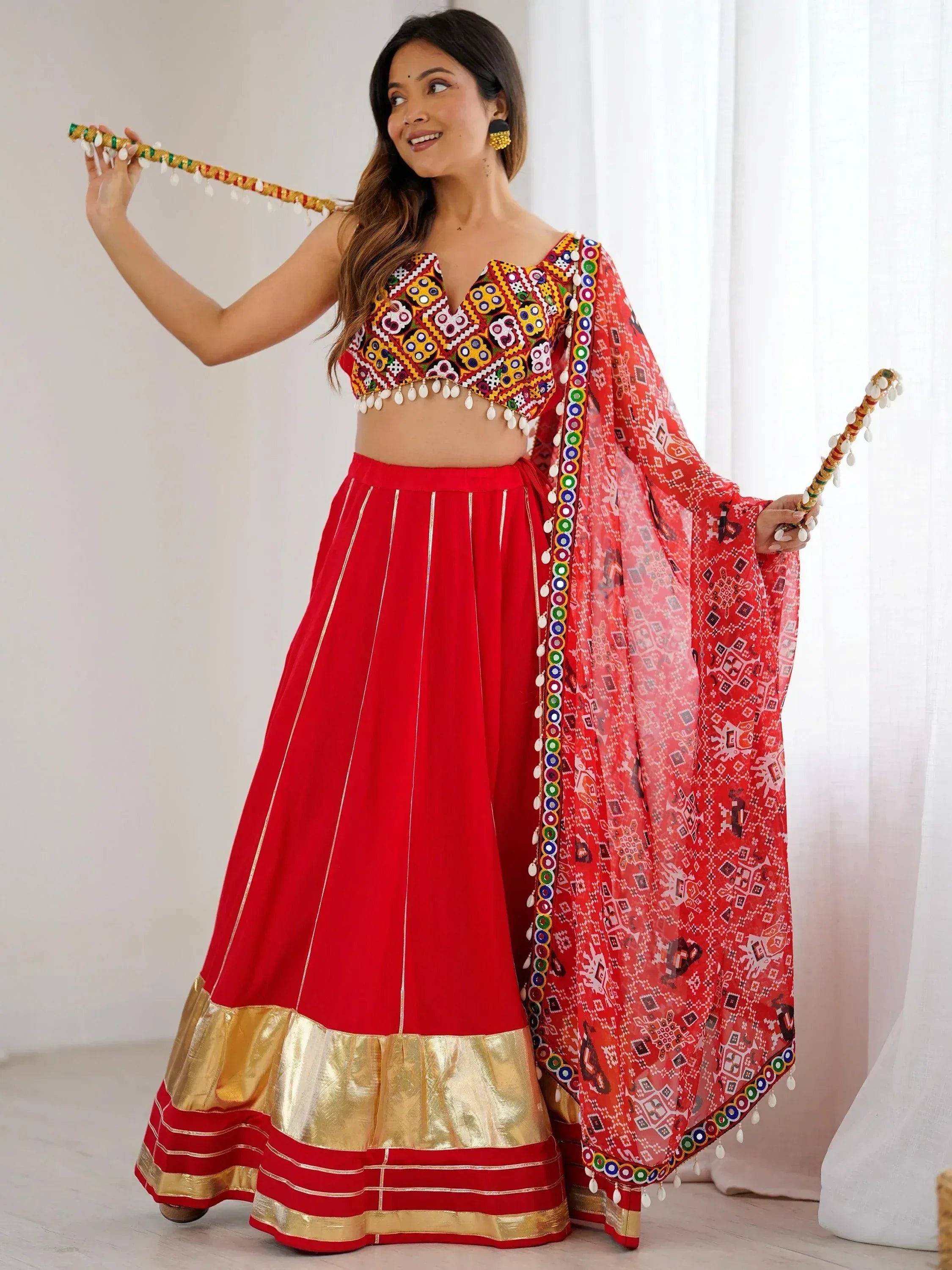 Red embroidered lehenga choli with mirror work, gold border, and printed dupatta for Indian ethnic wear