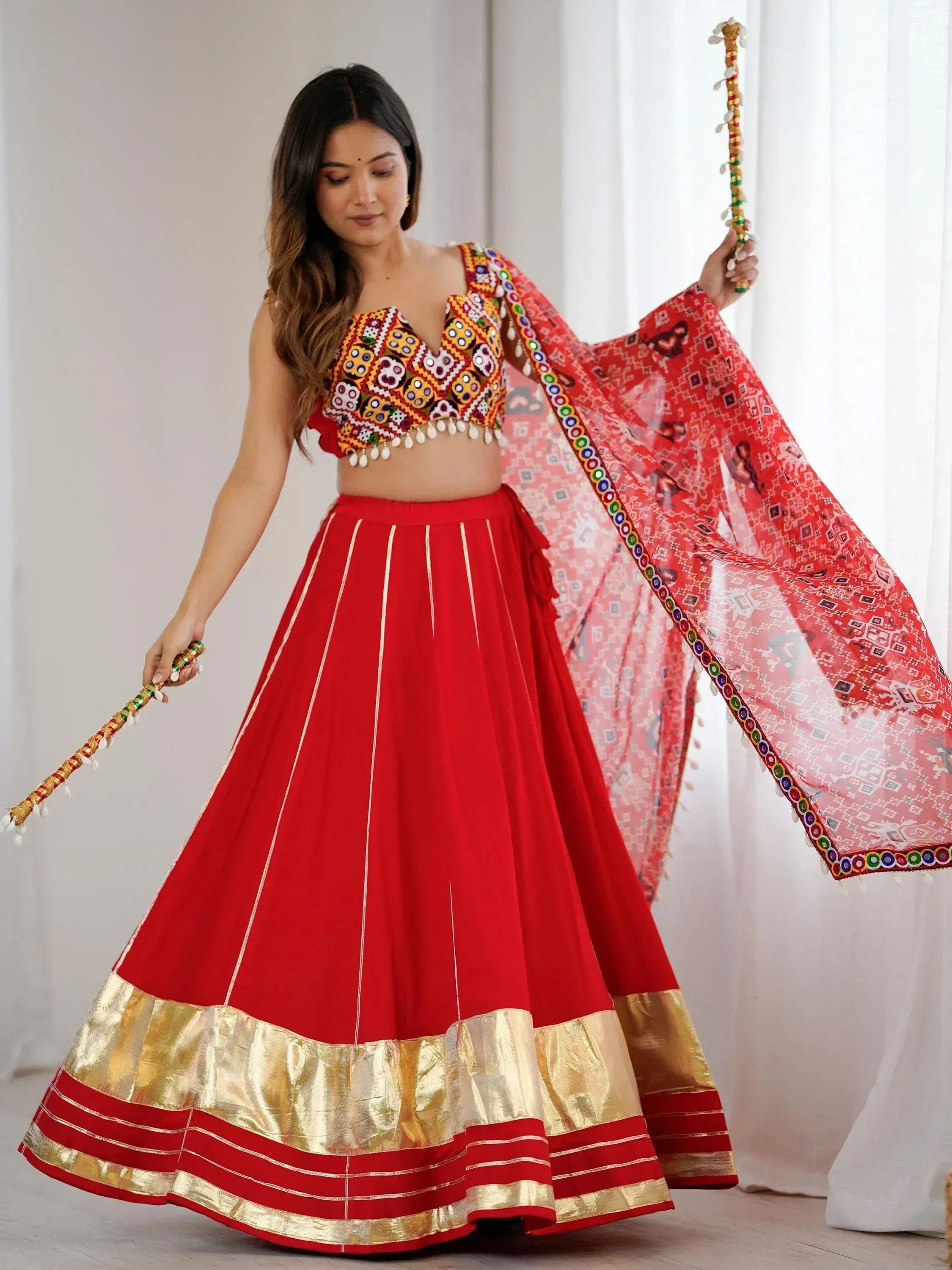 Red embroidered lehenga choli with mirror work, gold border, and dupatta for Indian ethnic wear