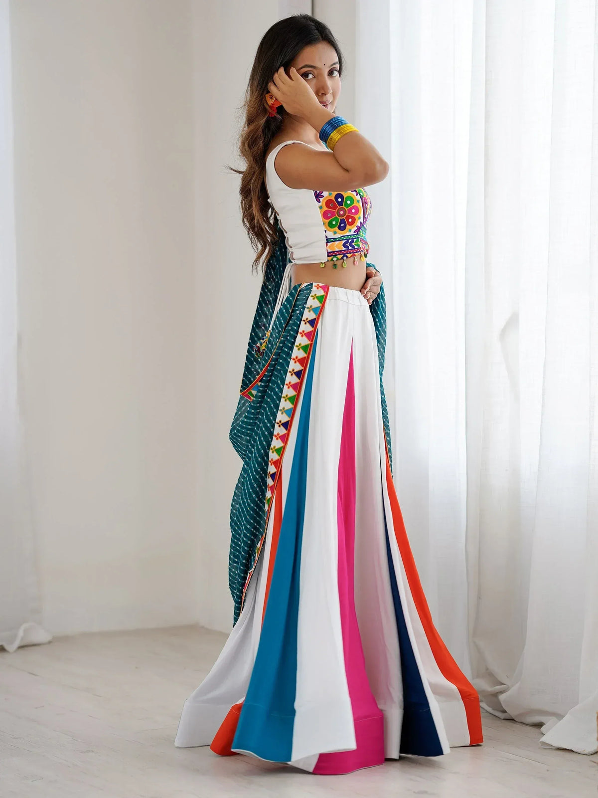 Woman in colorful embroidered lehenga choli with floral top and striped skirt, Indian ethnic wear