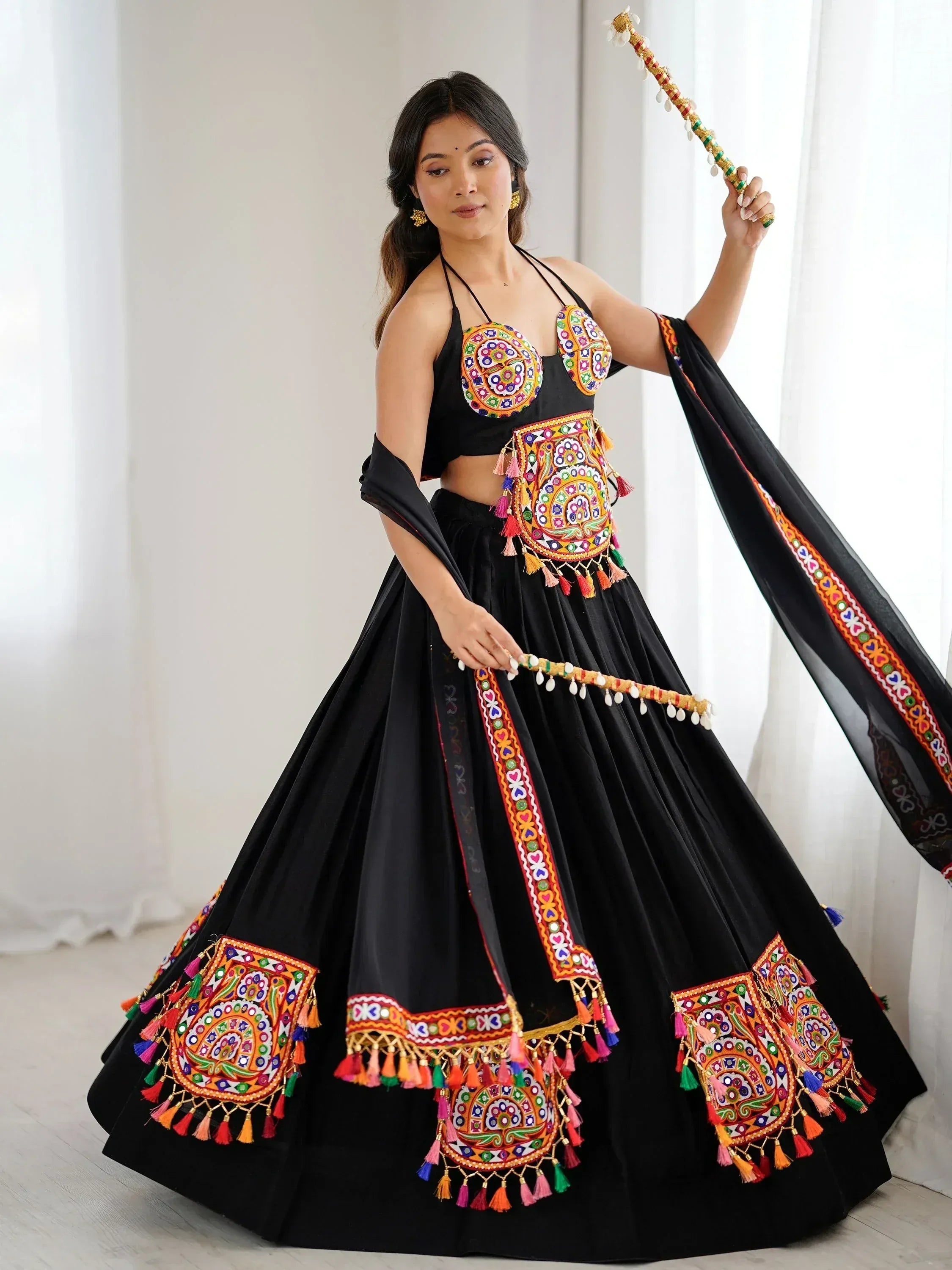 Black embroidered lehenga choli with colorful mirror work and tassels, perfect for Indian ethnic wear