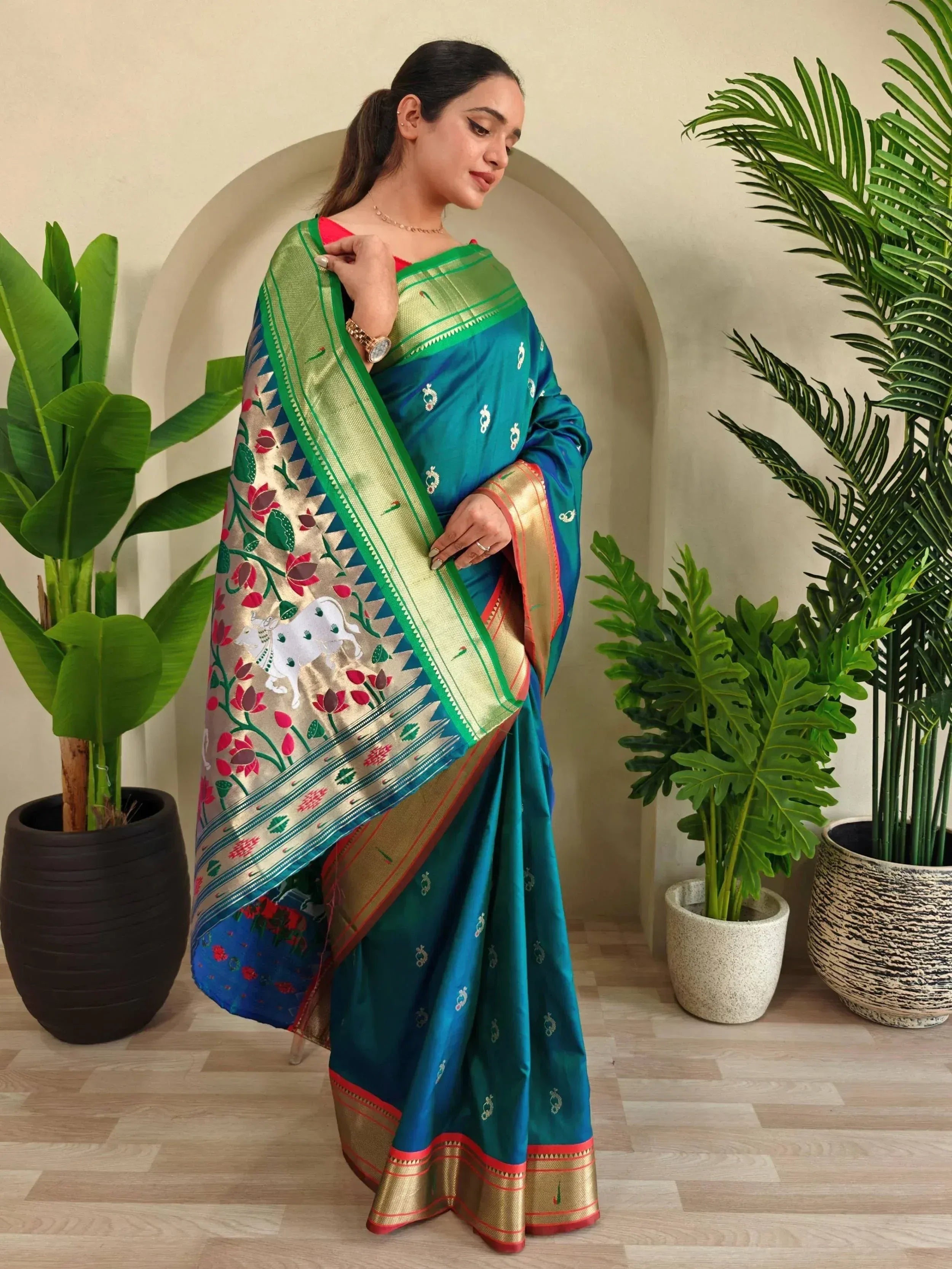 Teal silk saree with floral and cow motifs, gold border, perfect for Indian ethnic wear occasions