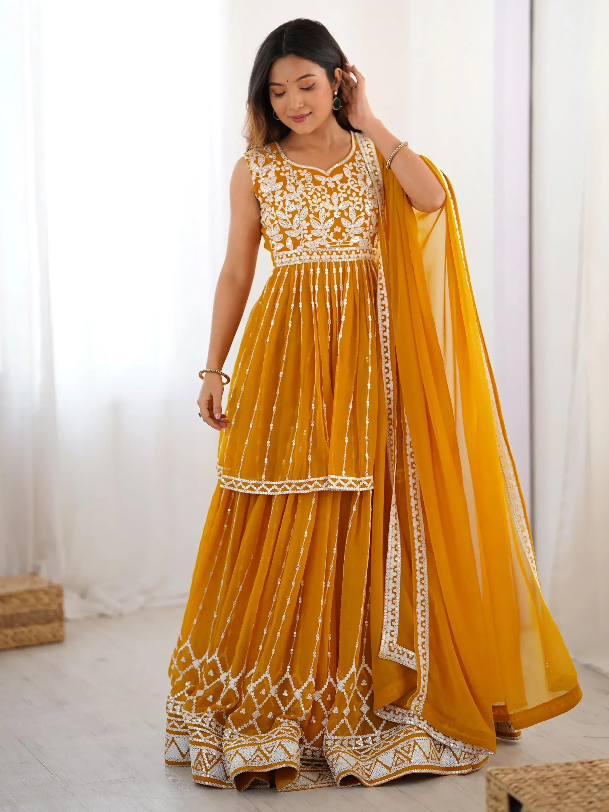 Mustard yellow ethnic gown with white embroidery and sequins, perfect for Indian occasions