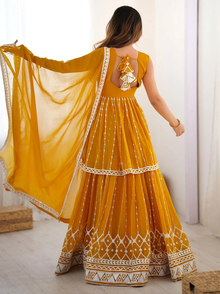 Mustard yellow ethnic gown with white embroidery and sheer dupatta, back view