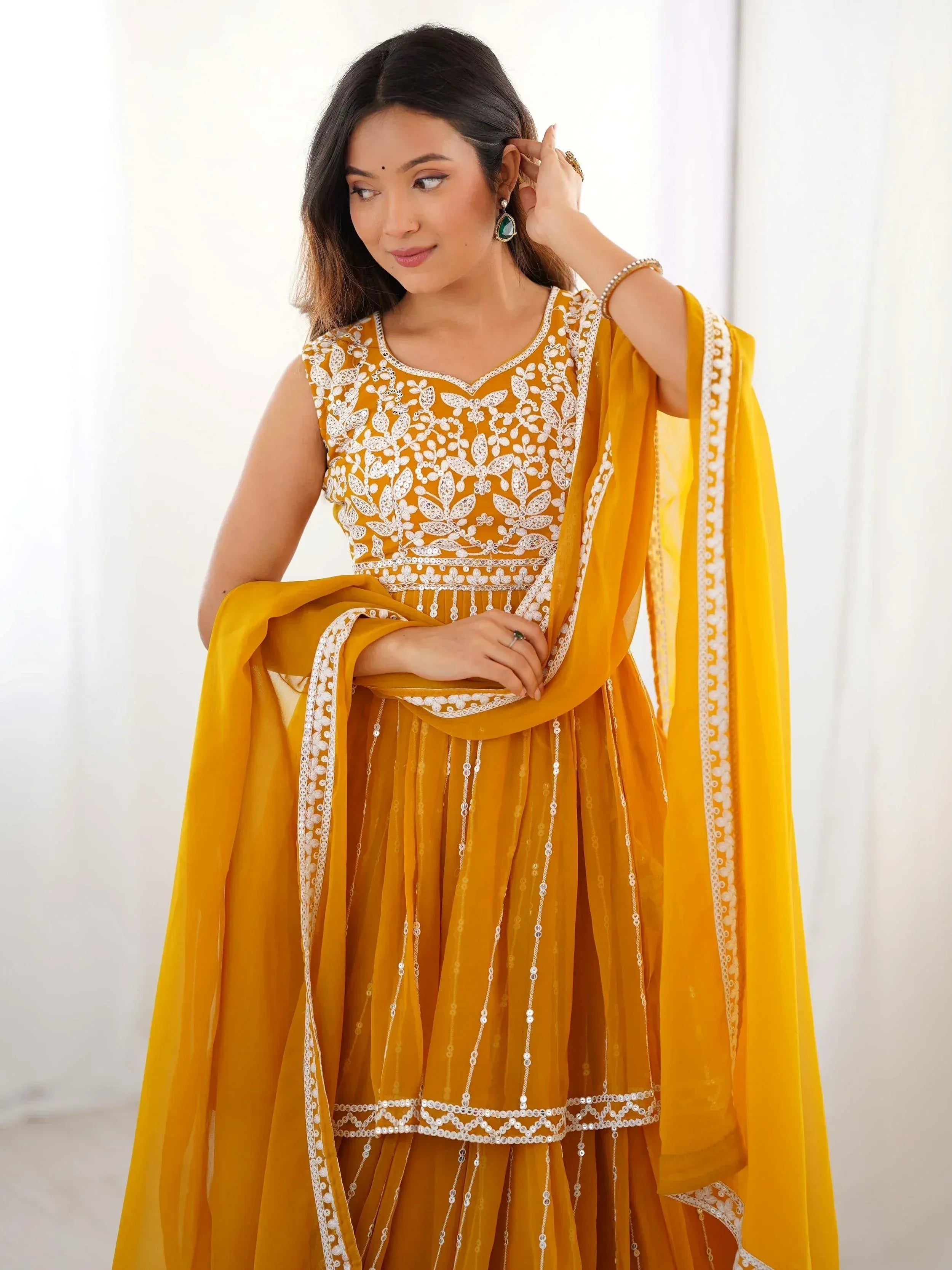 Yellow embroidered Indian ethnic wear with white lace and sequins, perfect for festive occasions