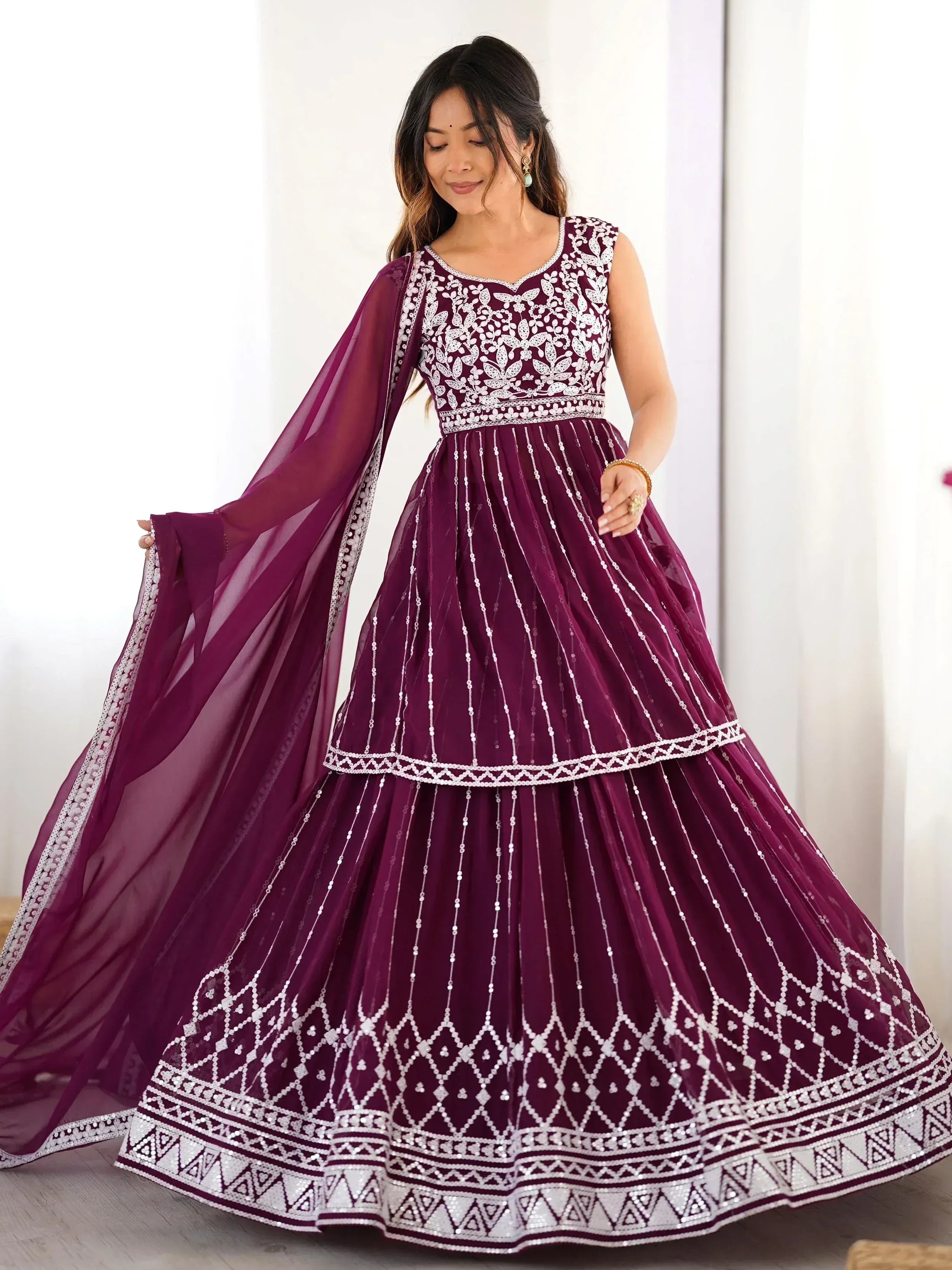 Elegant maroon ethnic gown with white embroidery and sequin detailing, perfect for Indian celebrations.