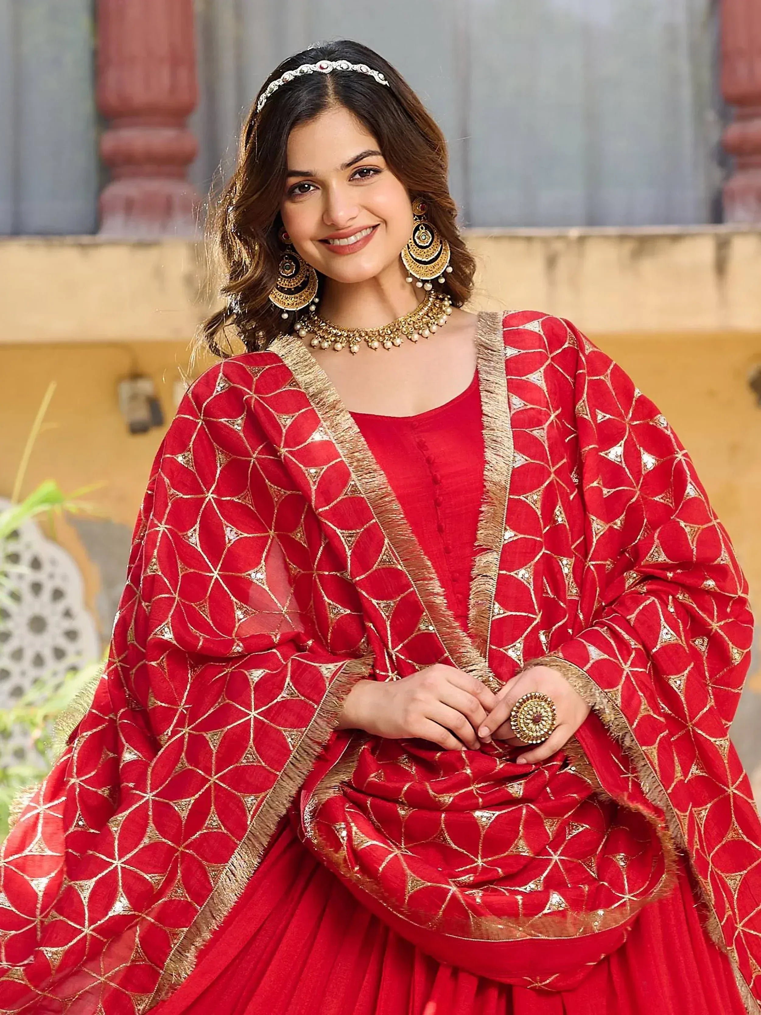 Red ethnic salwar kameez with gold embroidery and traditional jewelry for Indian wear