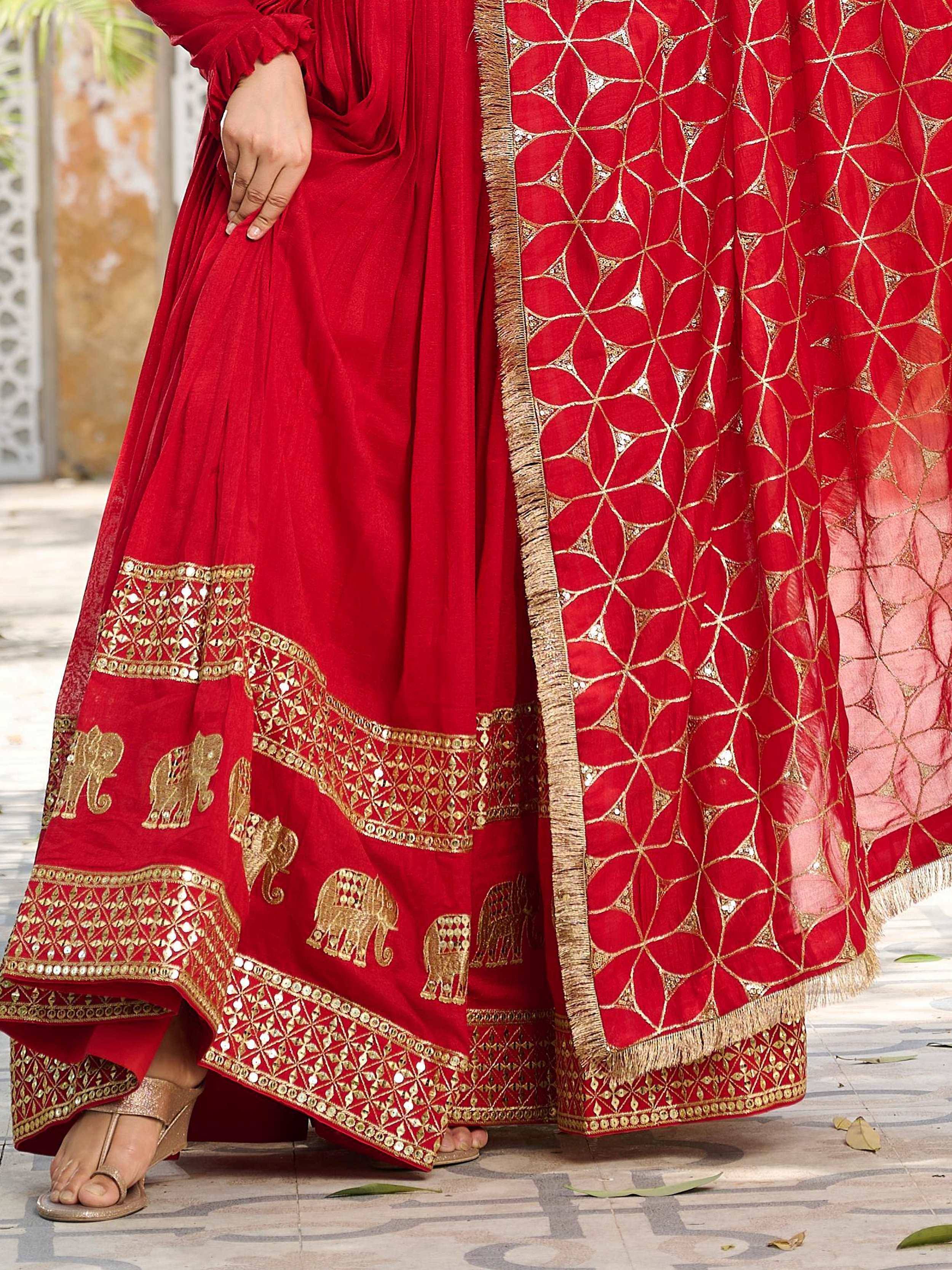 Red ethnic anarkali with gold elephant embroidery and geometric dupatta, perfect for Indian weddings or festivals.