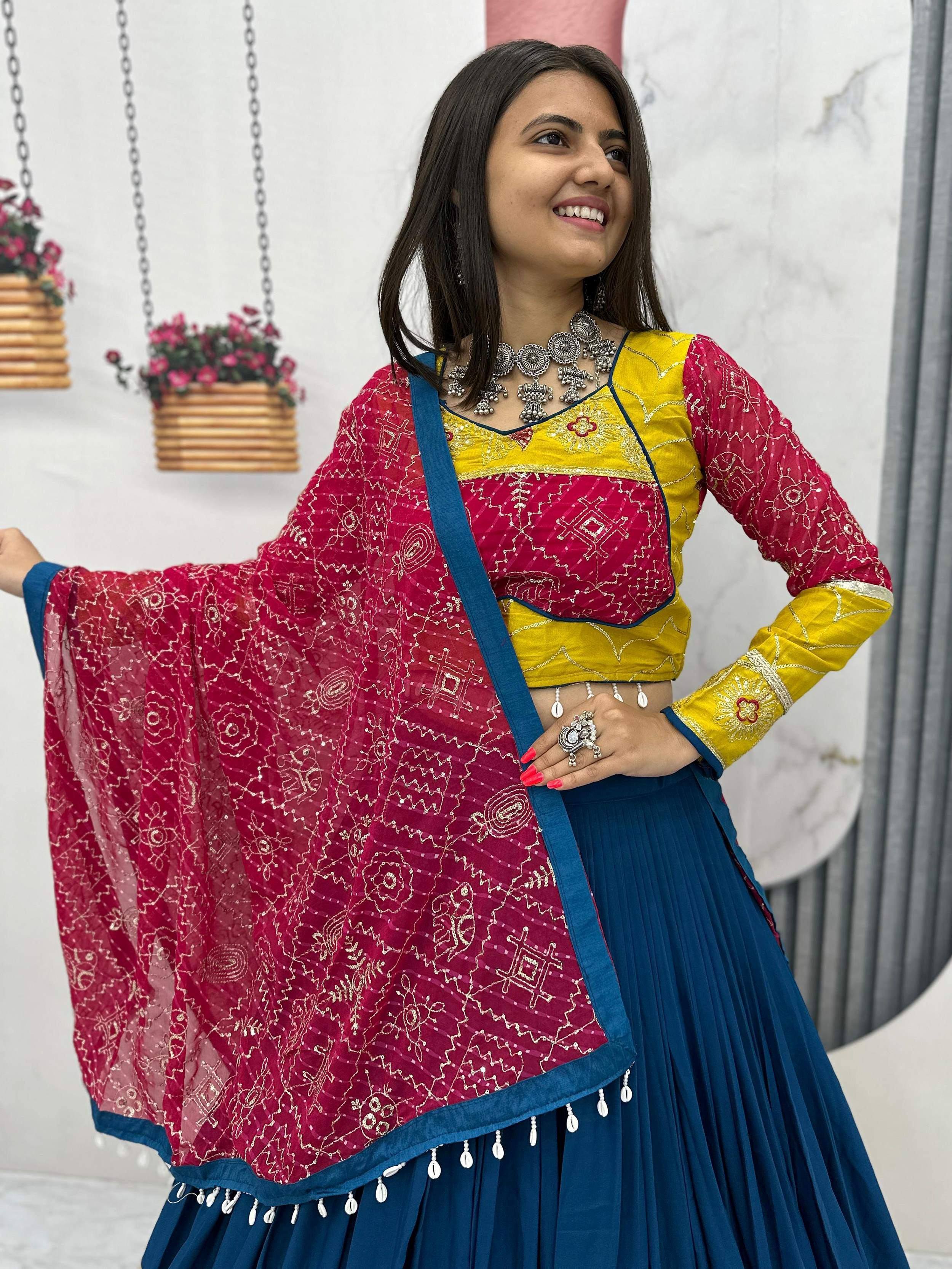 Woman in vibrant yellow and pink embroidered lehenga choli with blue dupatta, traditional Indian ethnic wear