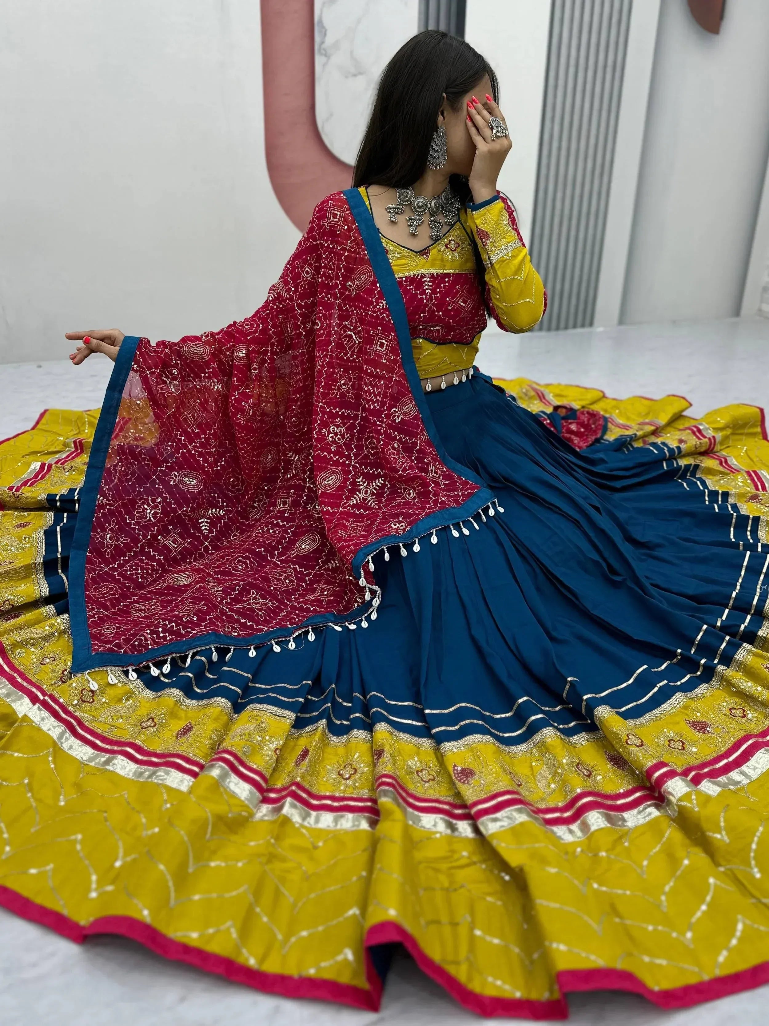Vibrant yellow and blue lehenga choli with red dupatta, perfect for Indian ethnic wear occasions.