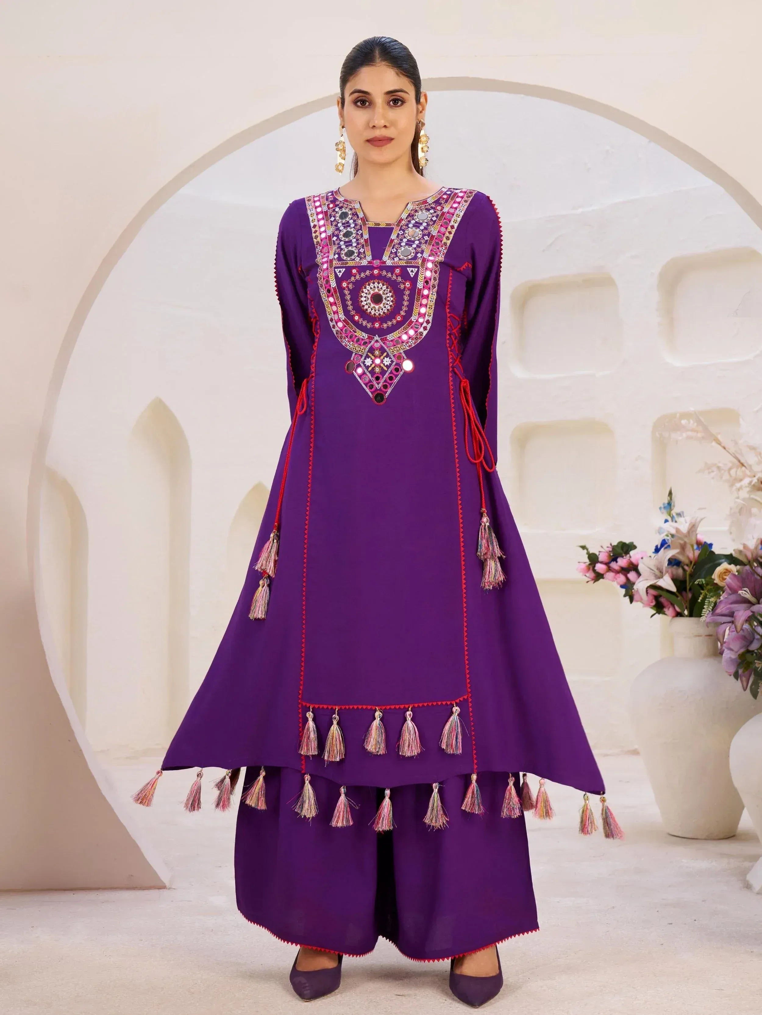 Purple ethnic kurta with mirror work and tassels, paired with palazzo pants for festive occasions