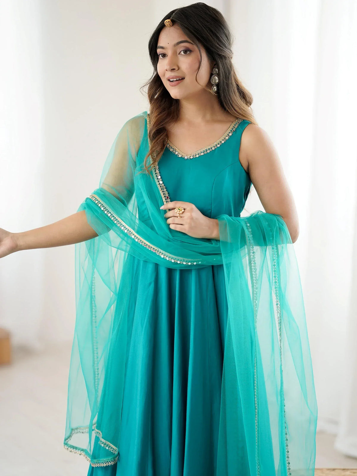 Teal ethnic gown with sheer dupatta and gold embroidery, perfect for Indian occasions