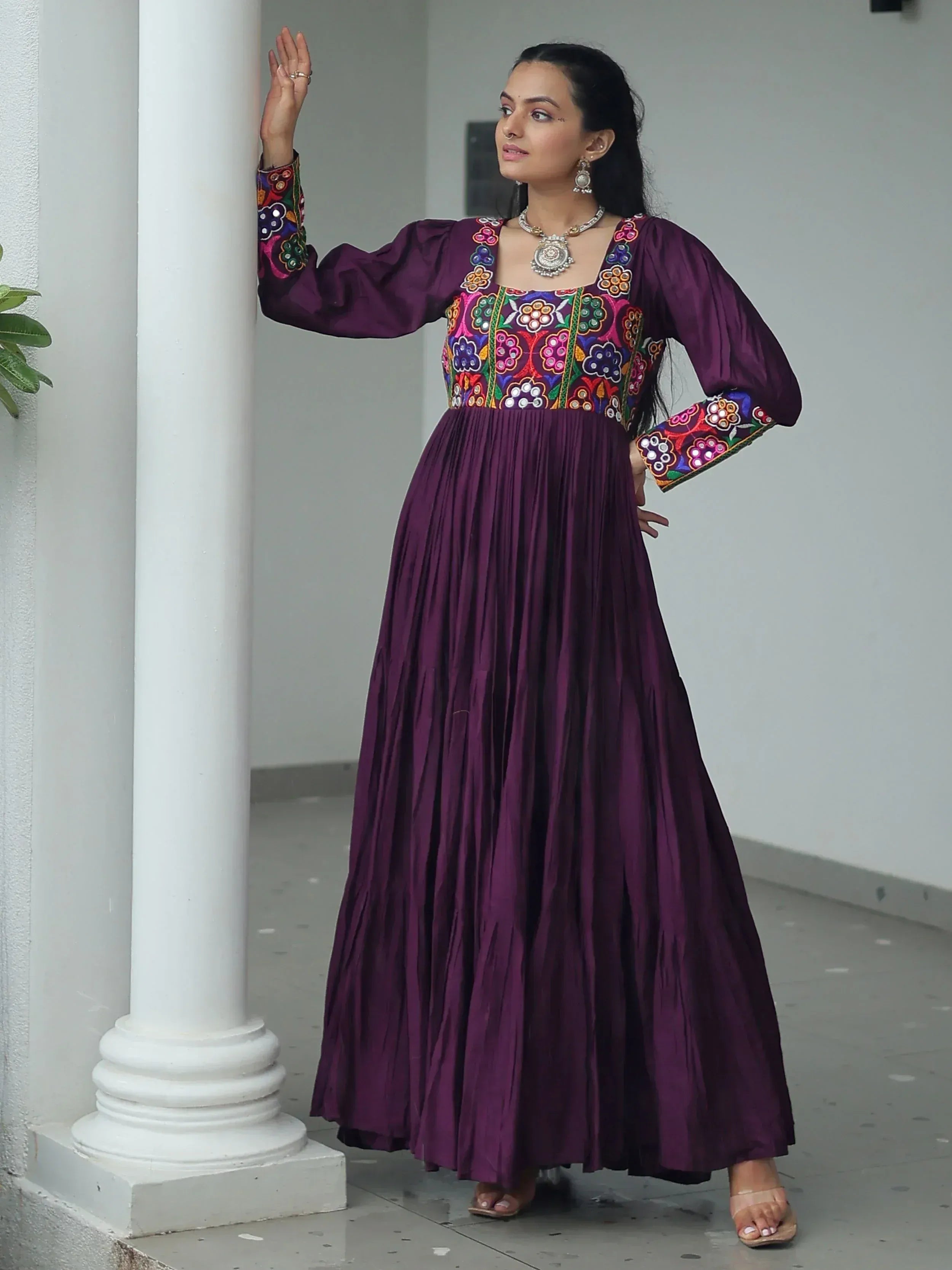 Purple ethnic gown with colorful floral embroidery, pleated skirt, and long sleeves for Indian wear