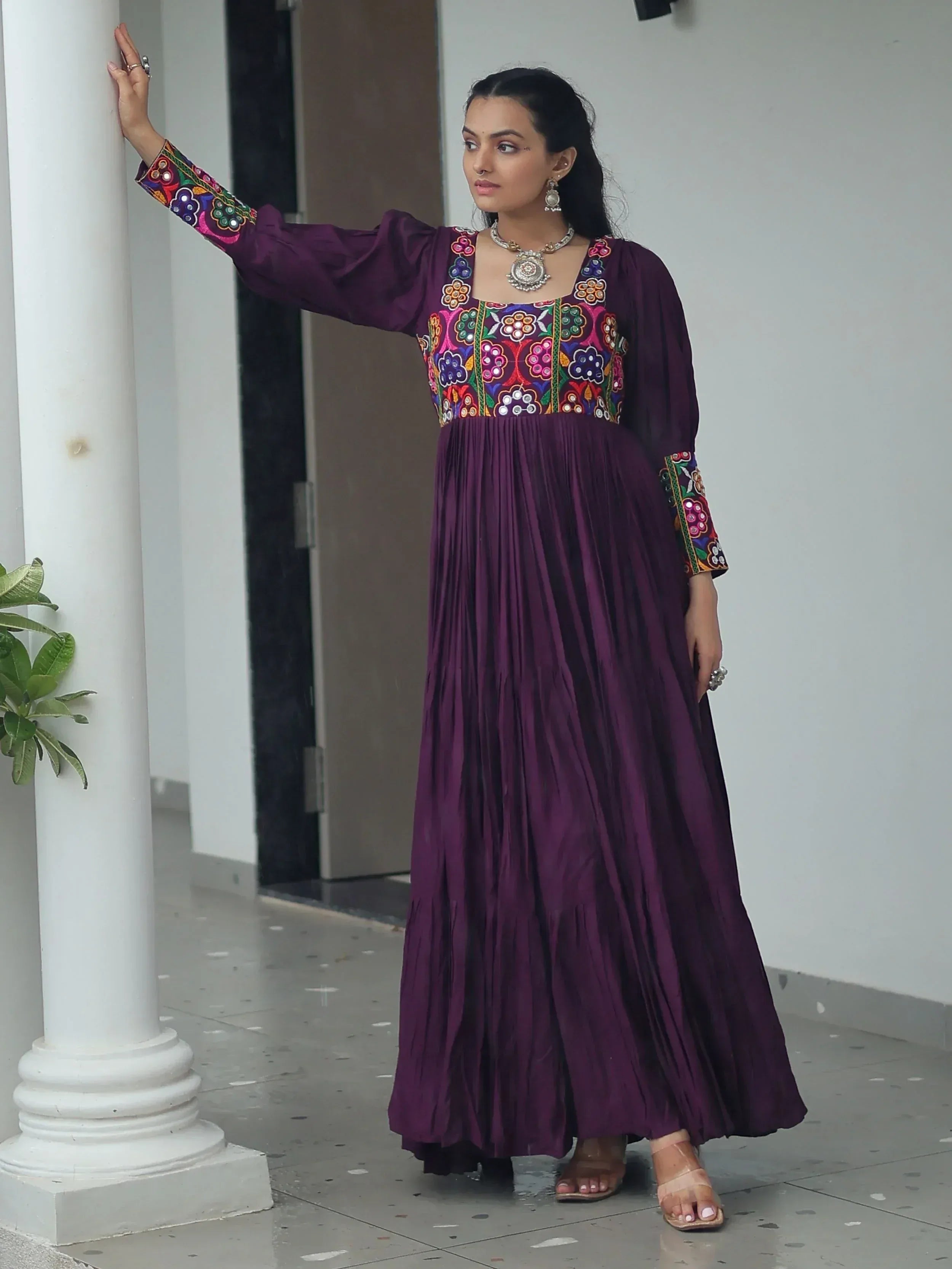 Purple ethnic gown with colorful floral embroidery, pleated skirt, and long sleeves for women