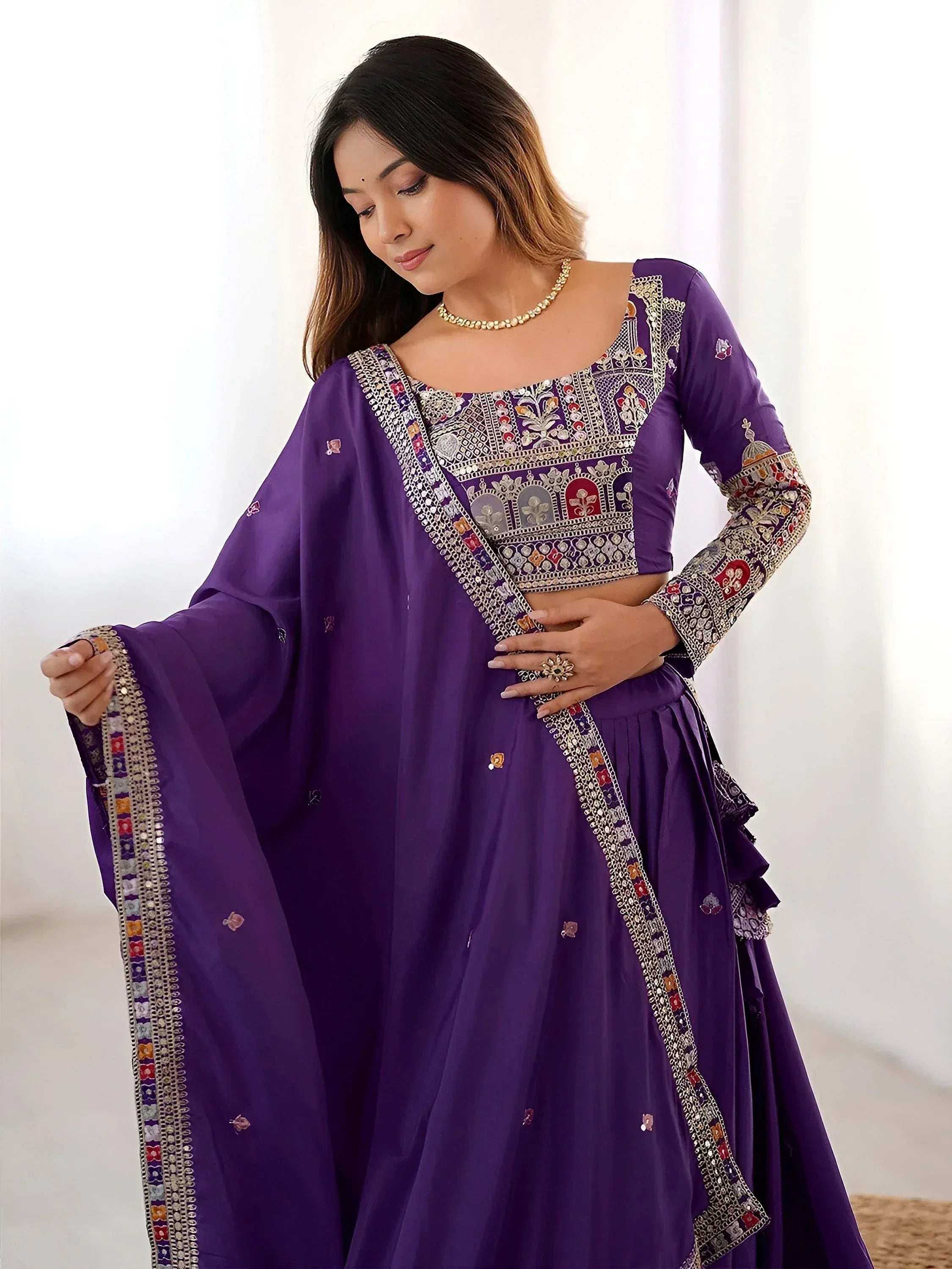 Purple embroidered lehenga choli with detailed mirror work and floral motifs, perfect for Indian ethnic occasions.