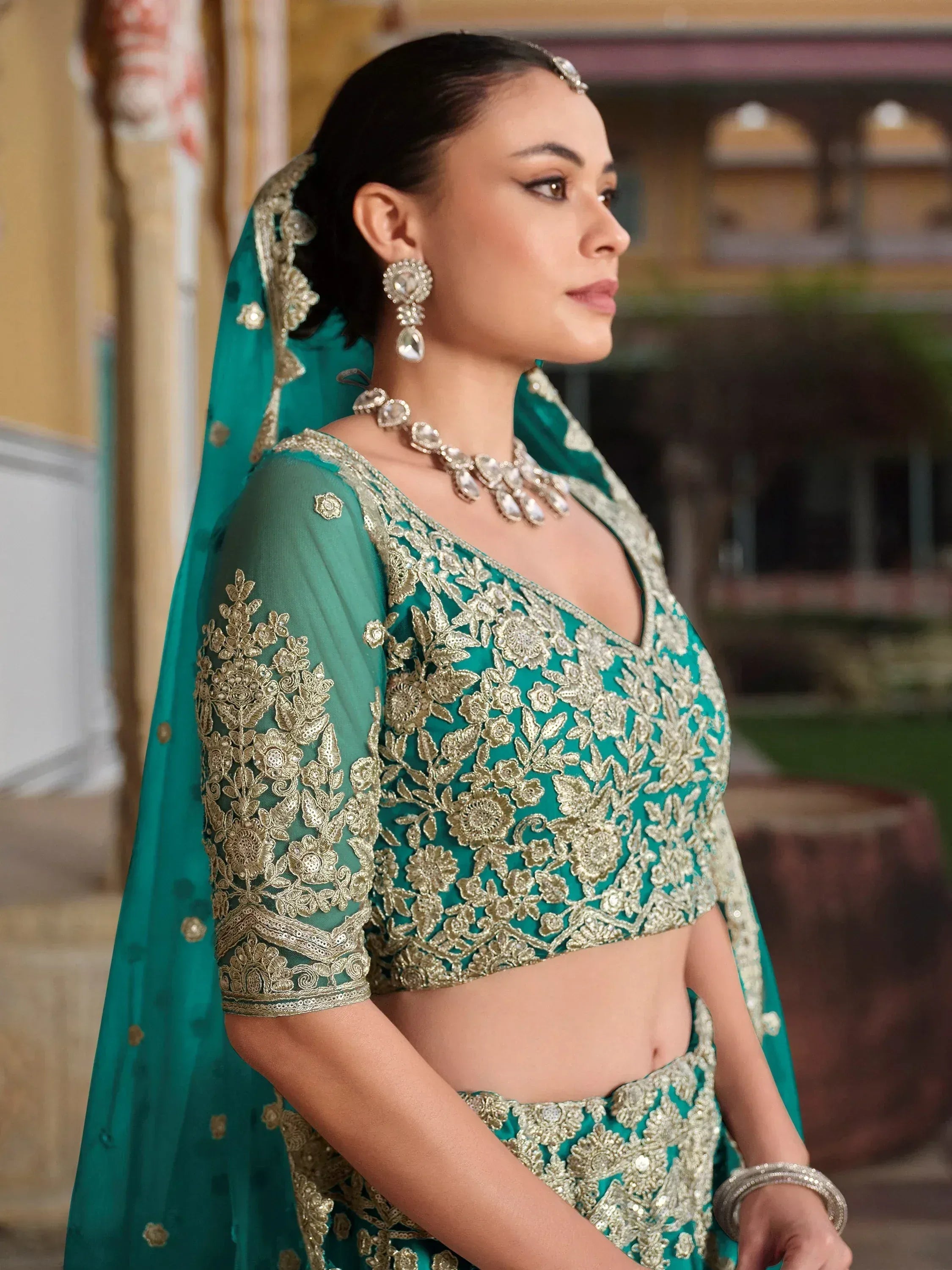 Emerald green designer lehenga choli with gold embroidery, perfect for Indian weddings and festive occasions.